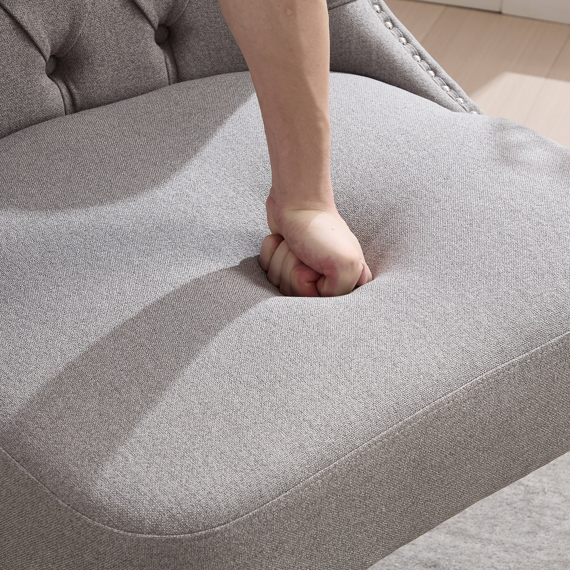 Hand pressing seat cushion to show softness