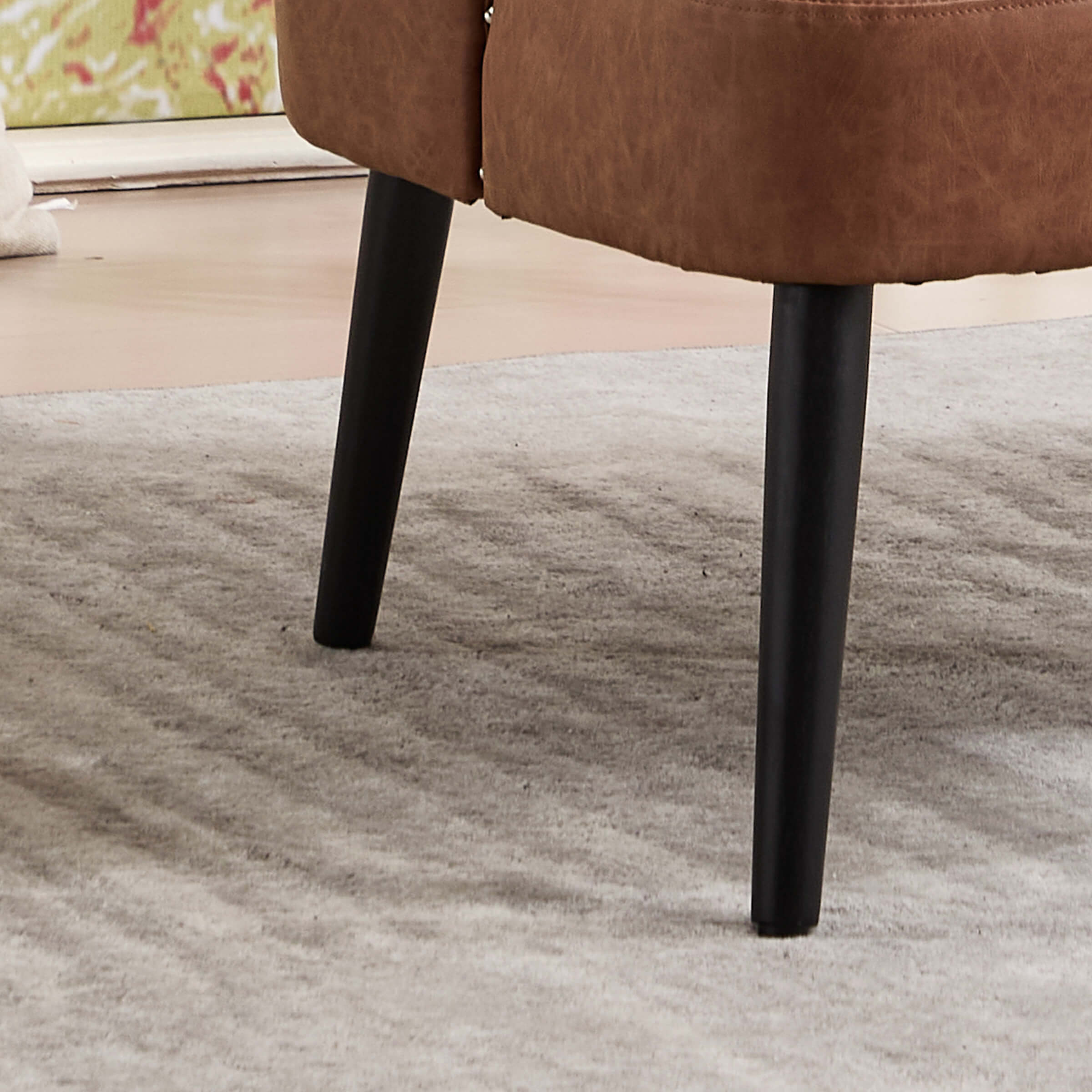 Leg of brown chair on rug