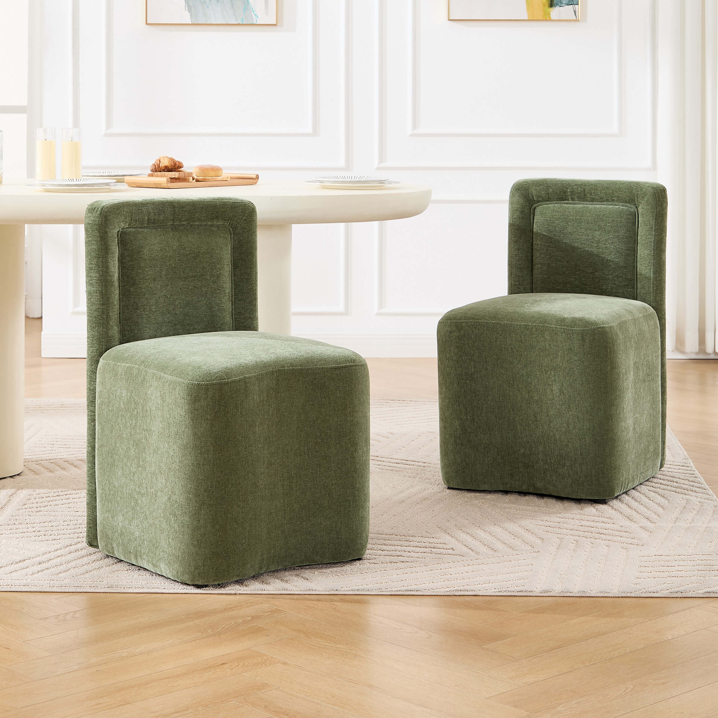 Two green upholstered cube stools with backrest placed around a table