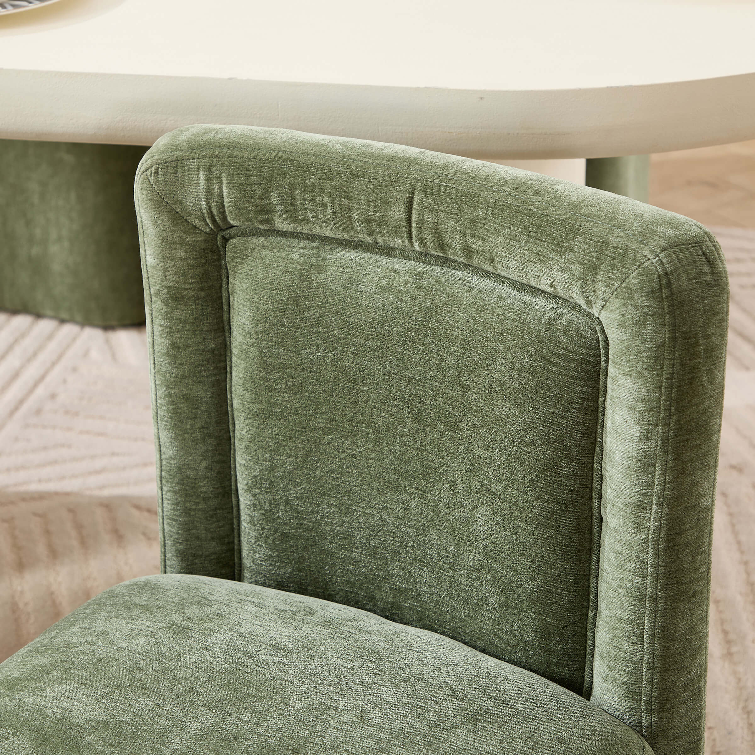 Close-up of the green upholstered chair back and stitching