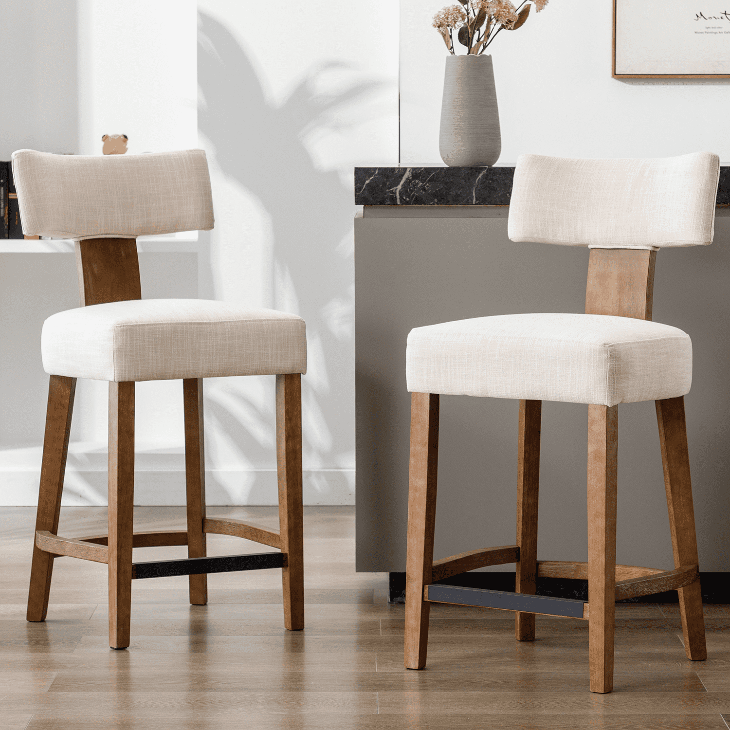 Two upholstered bar stools with light beige cushions near a kitchen island