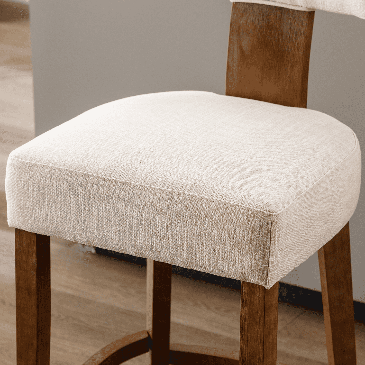 Close-up of the cream upholstery on a bar stool seat
