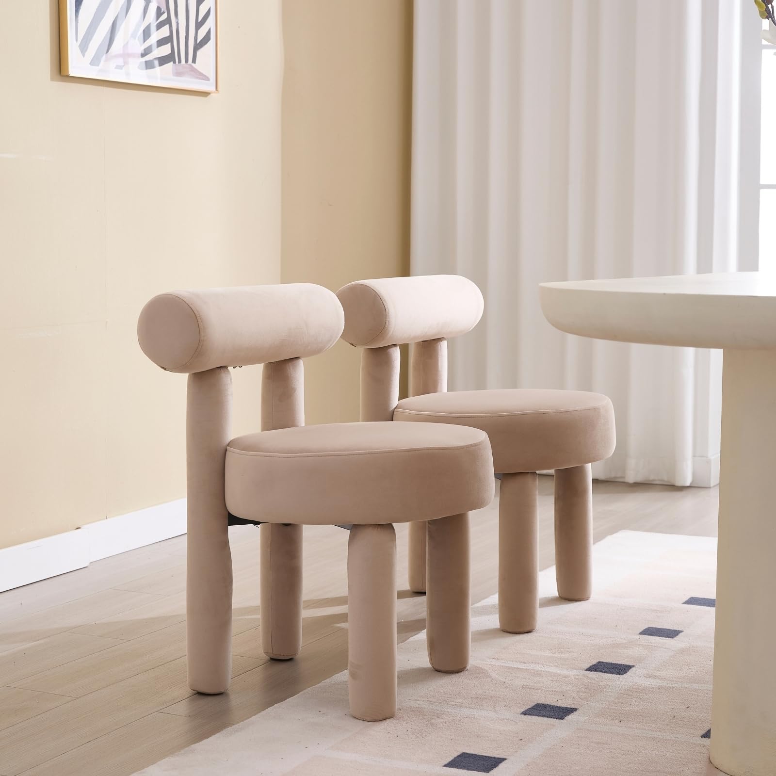 Beige chairs in room with art on wall