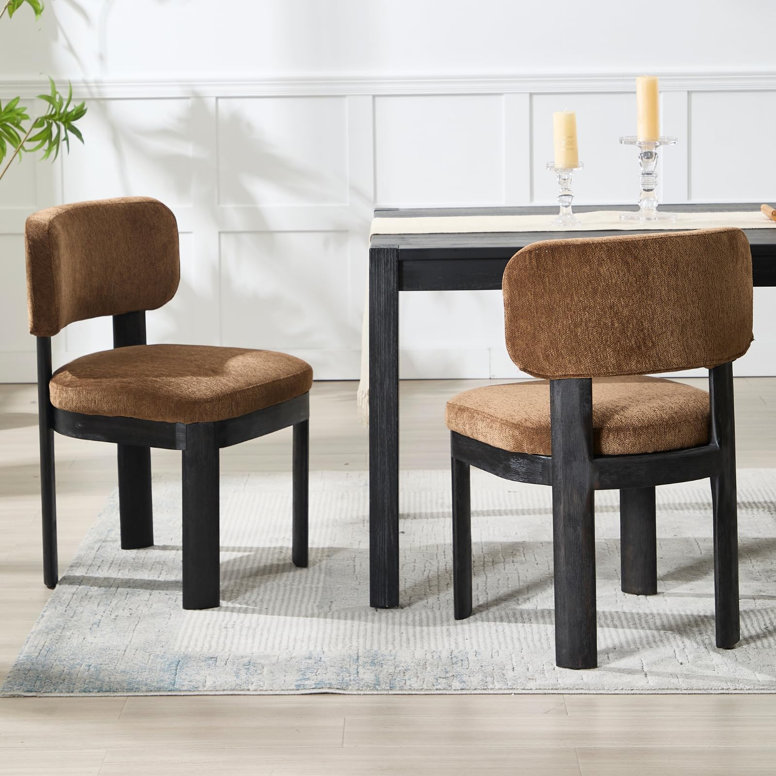 Two brown chairs around table with black legs
