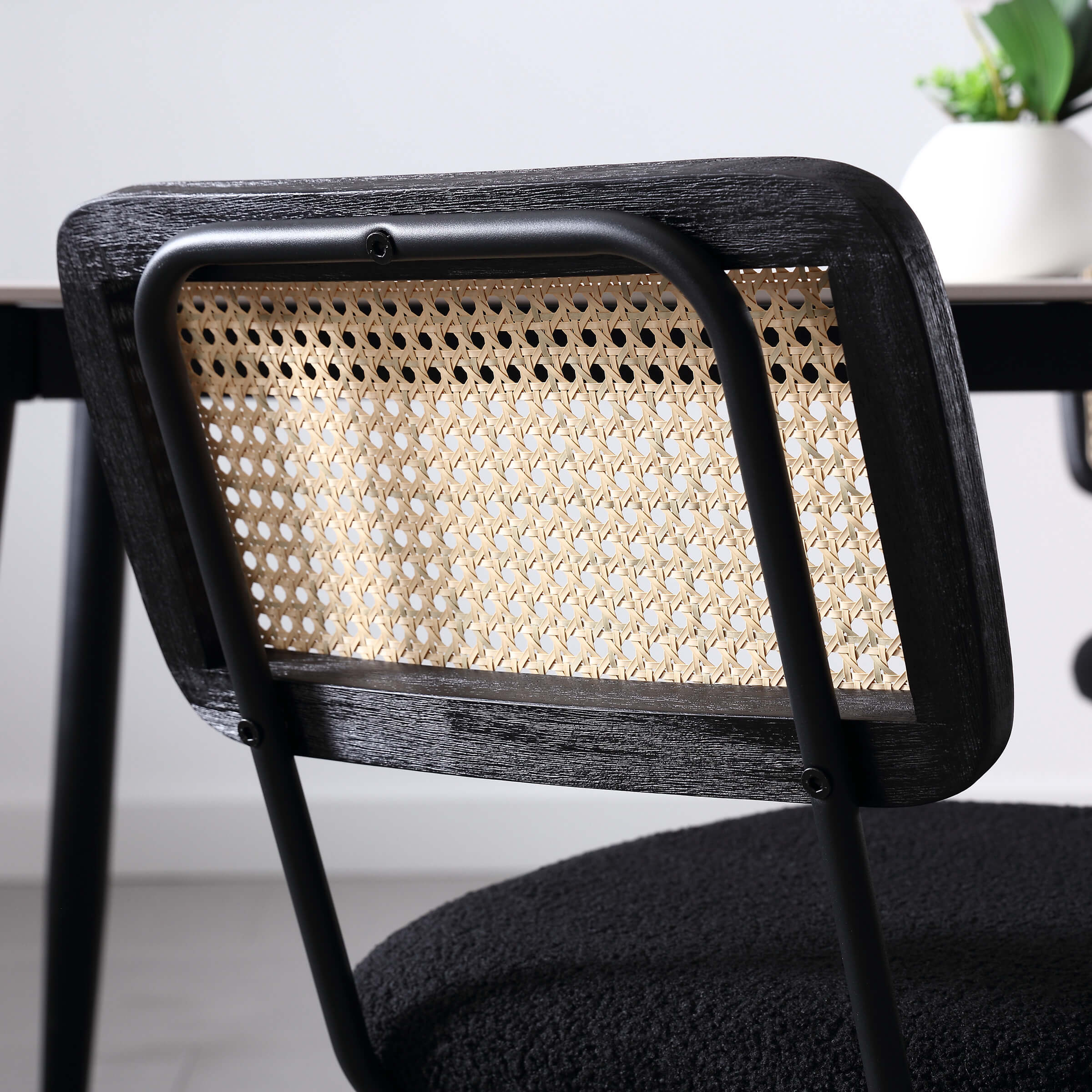 Close-up of chair back with woven cane and dark wood frame