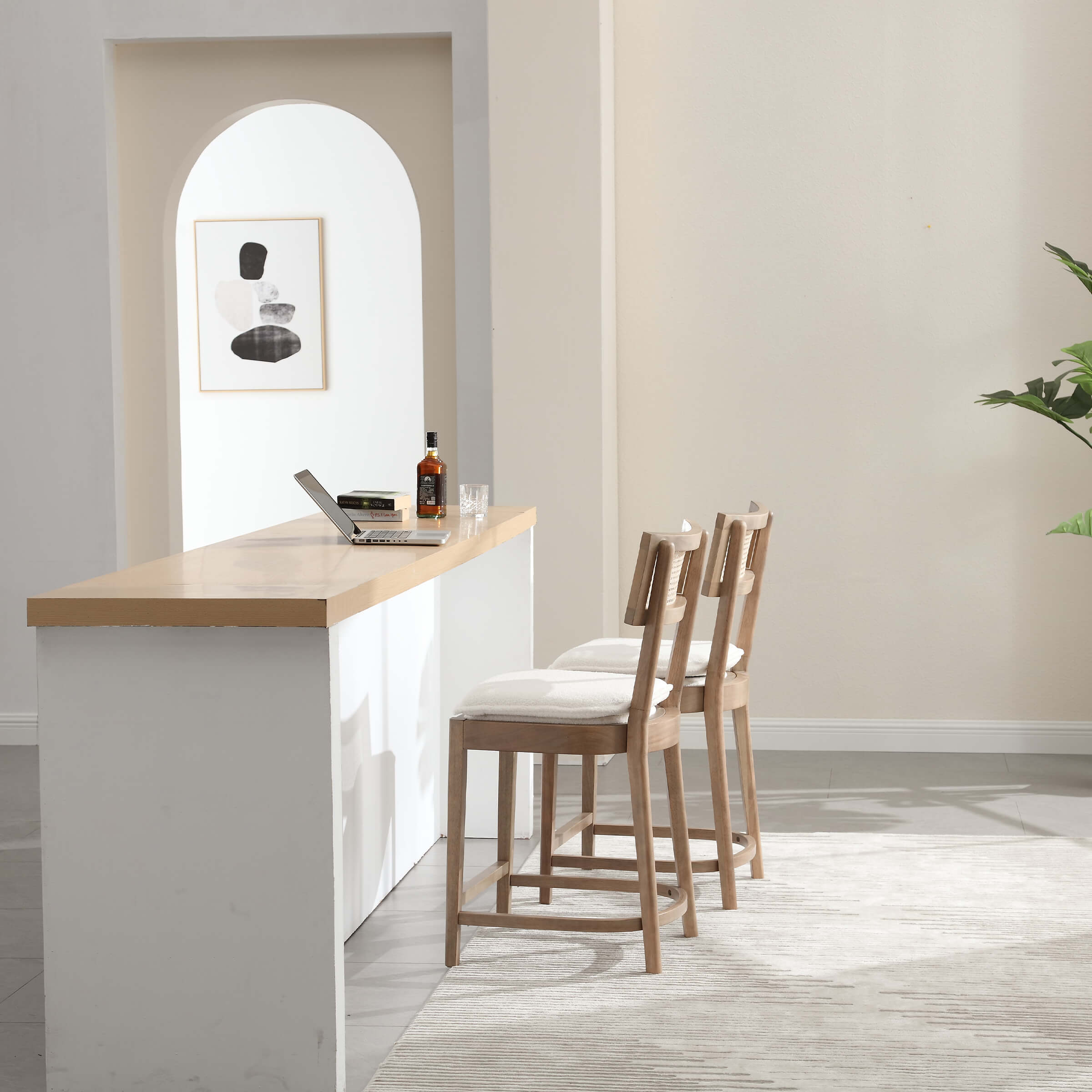 Two black stools by counter with plant in background