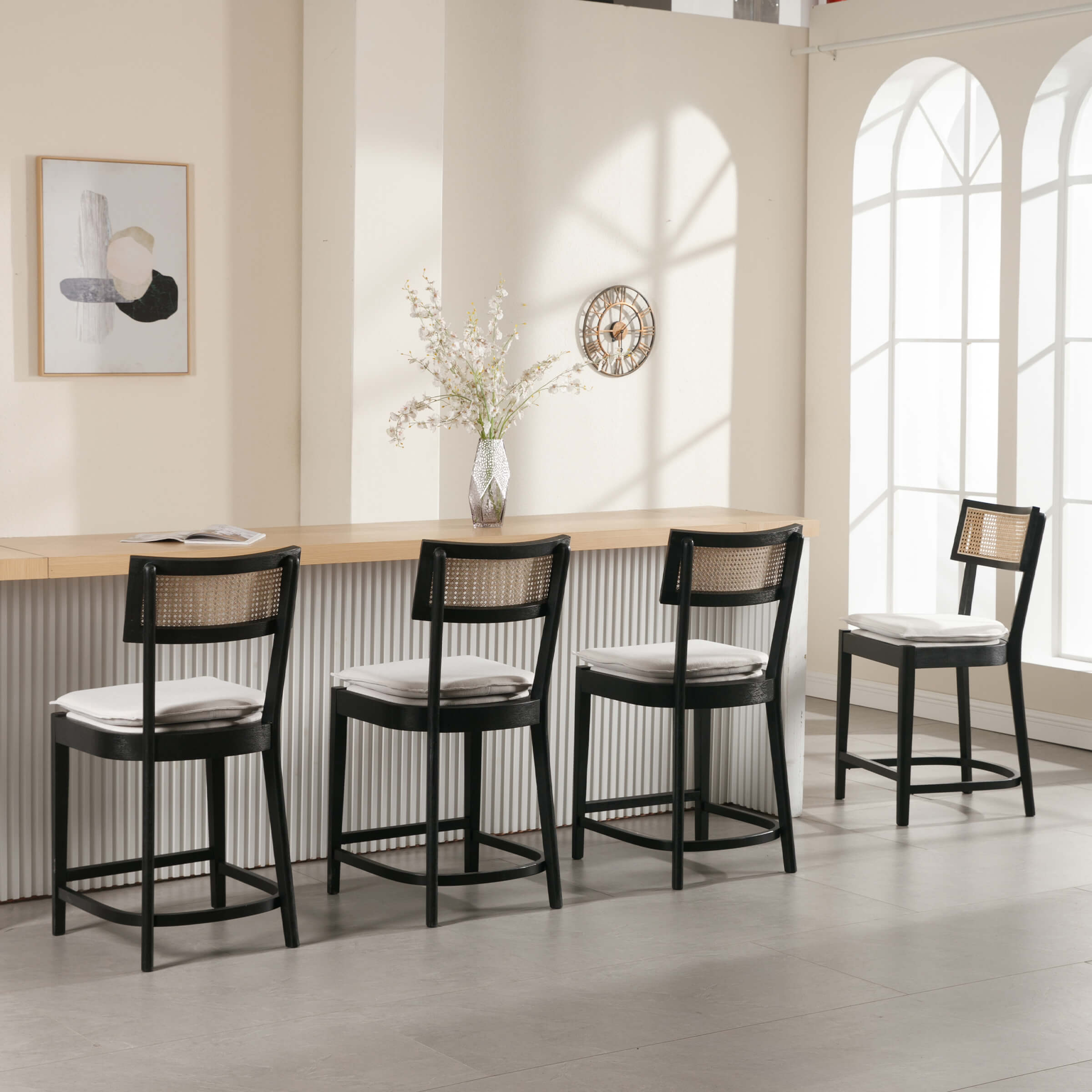 Row of three black counter stools and one additional stool at end