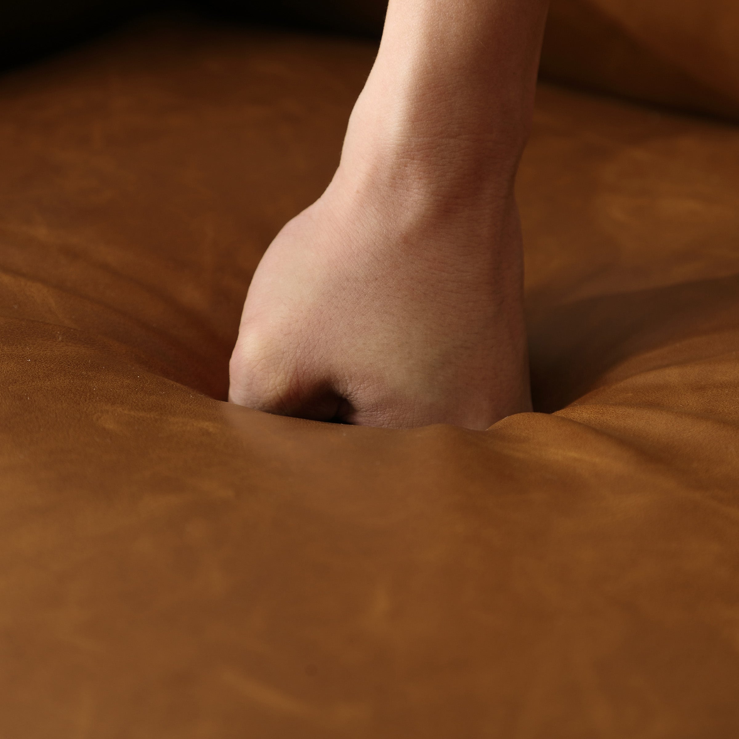 Close-up of hand pressing into leather