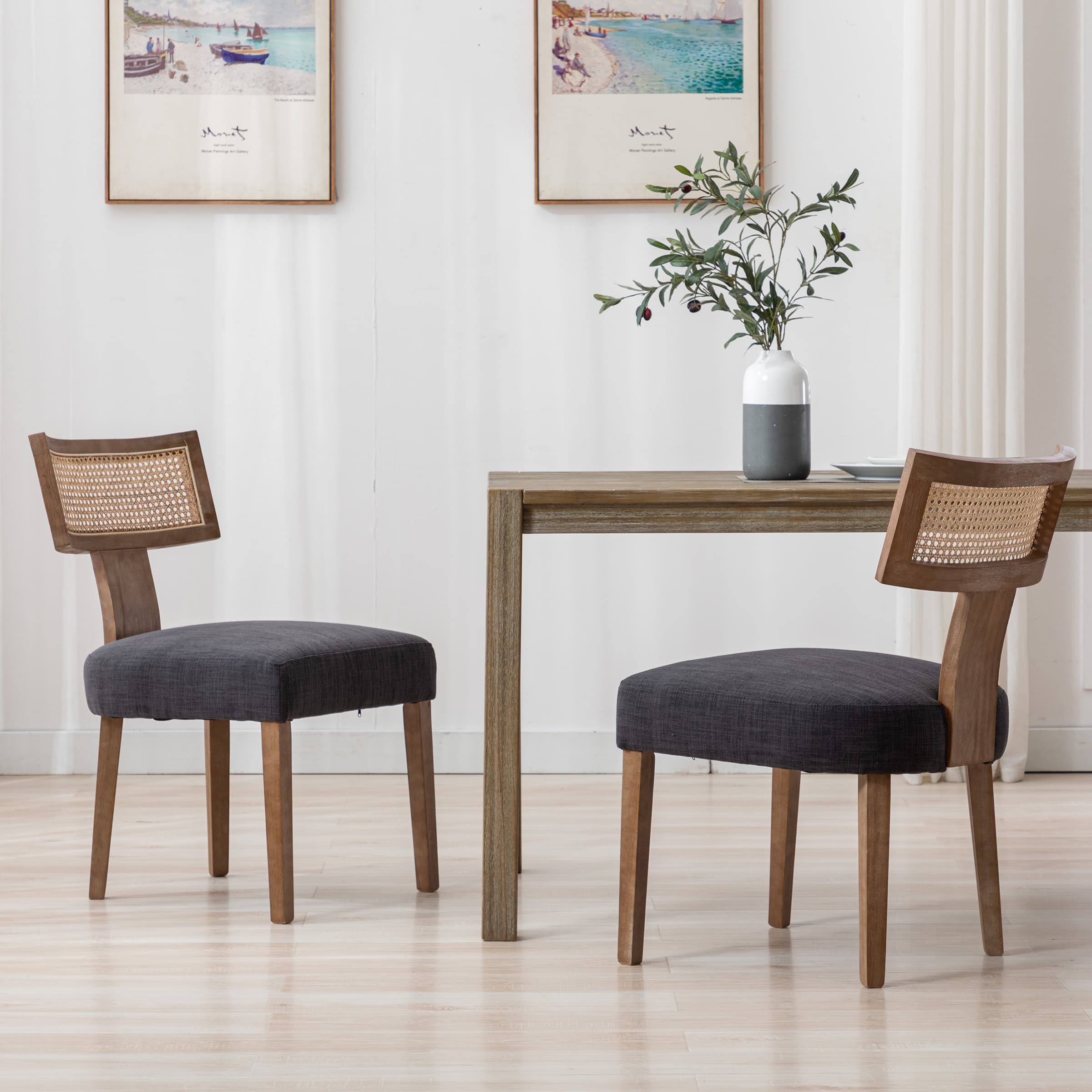 Two chairs around table with dark cushions