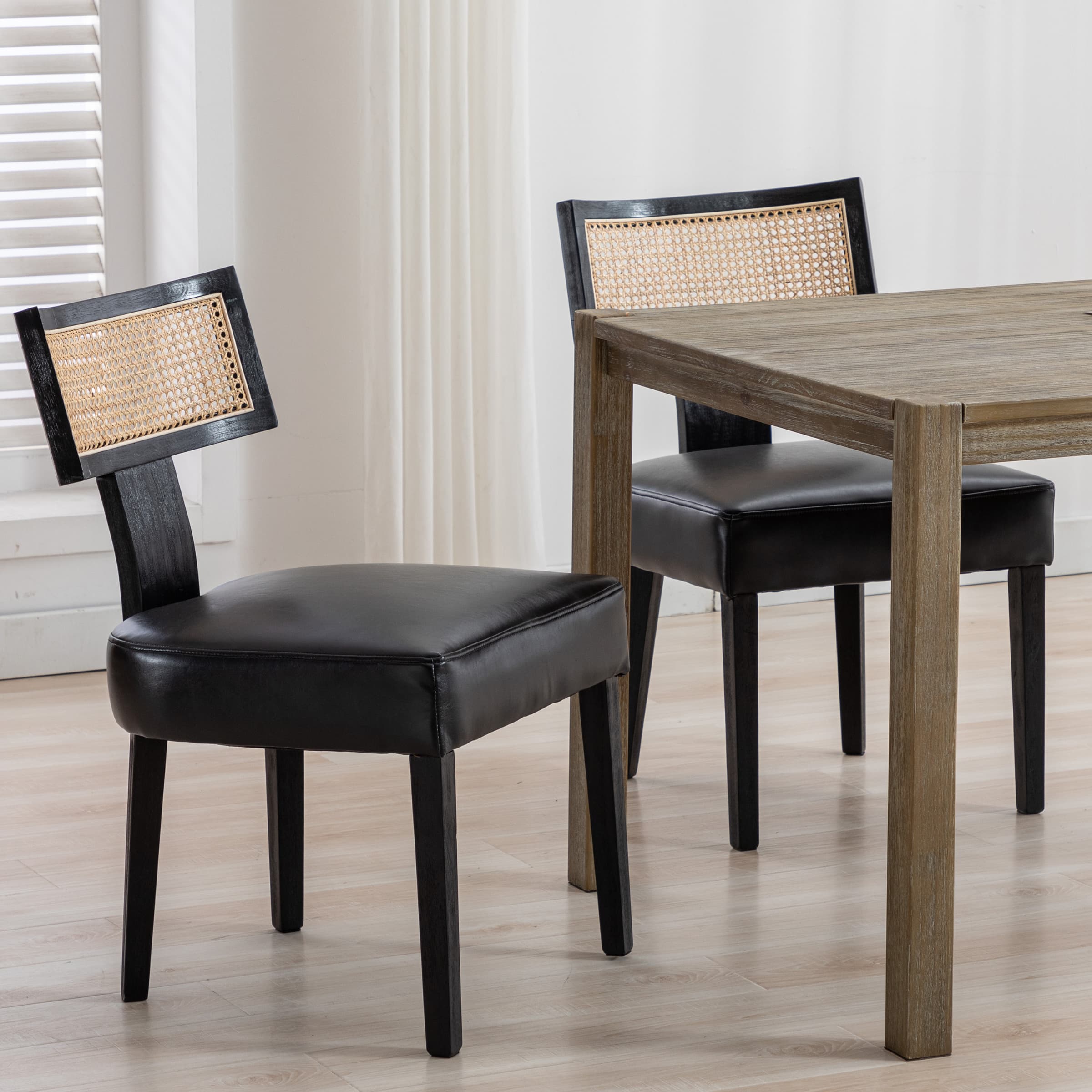 Two chairs with black seats around a table