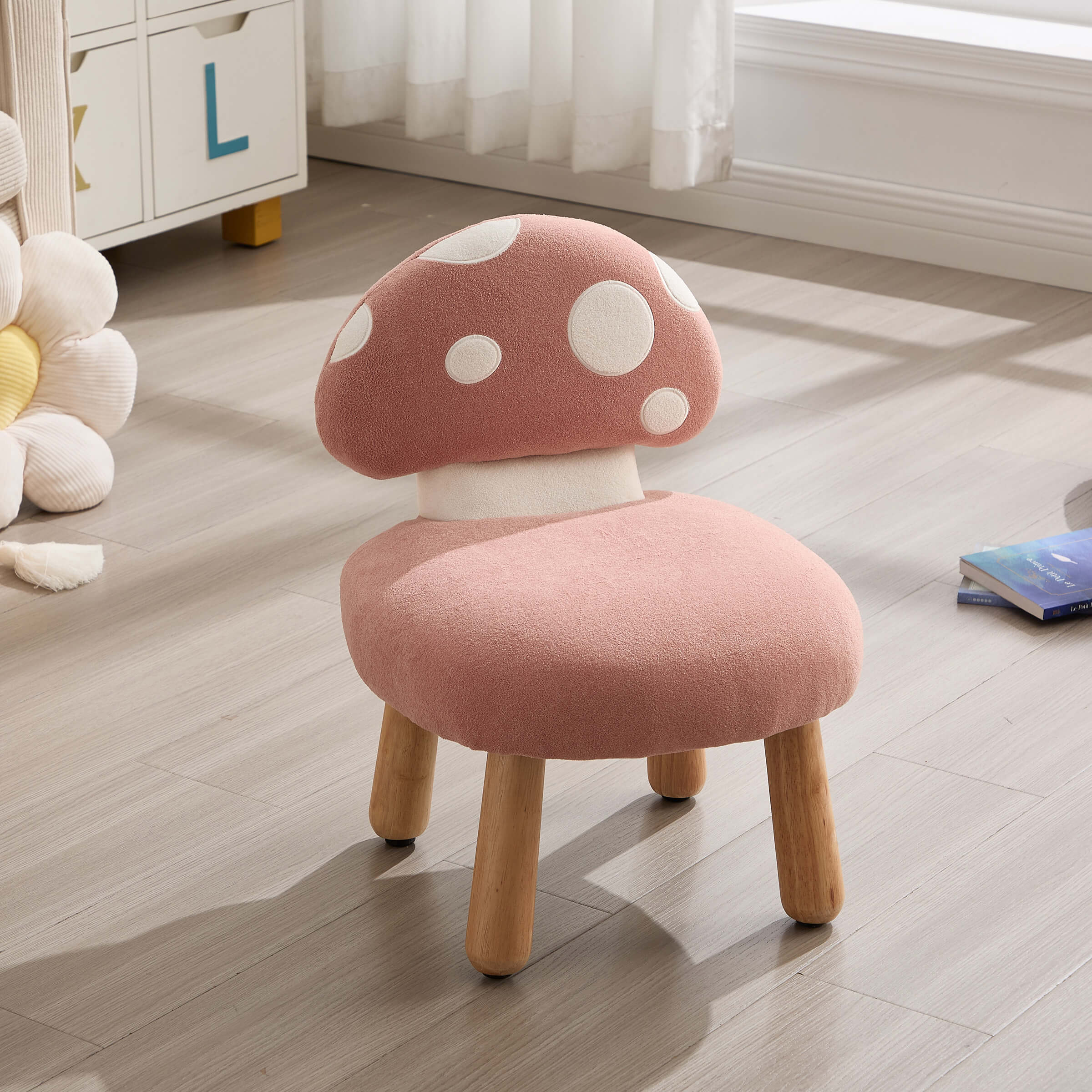 Pink mushroom-shaped stool on a wooden floor with a white curtain in the background