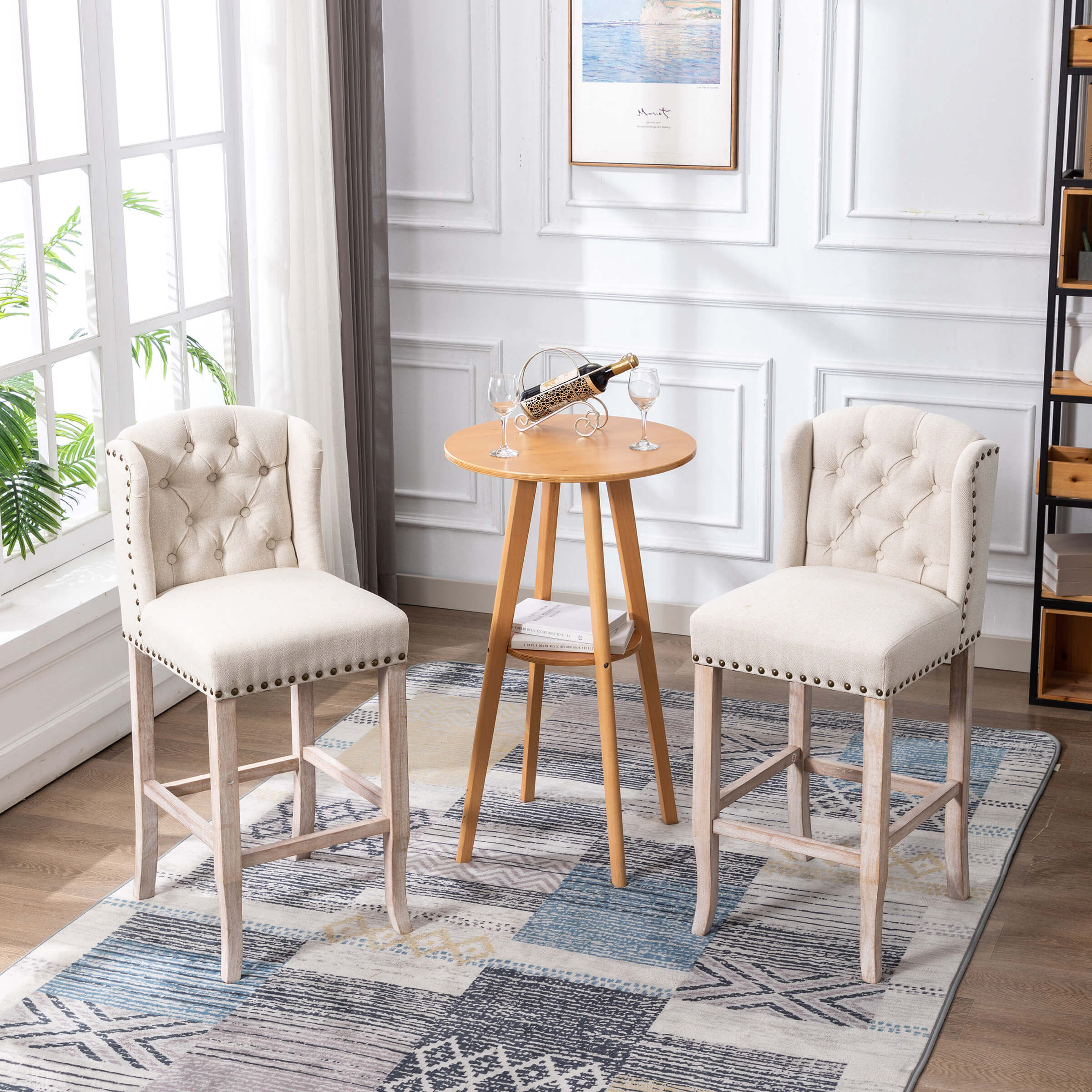 Two tufted beige counter stools with light wood legs around a small round table in a dining area