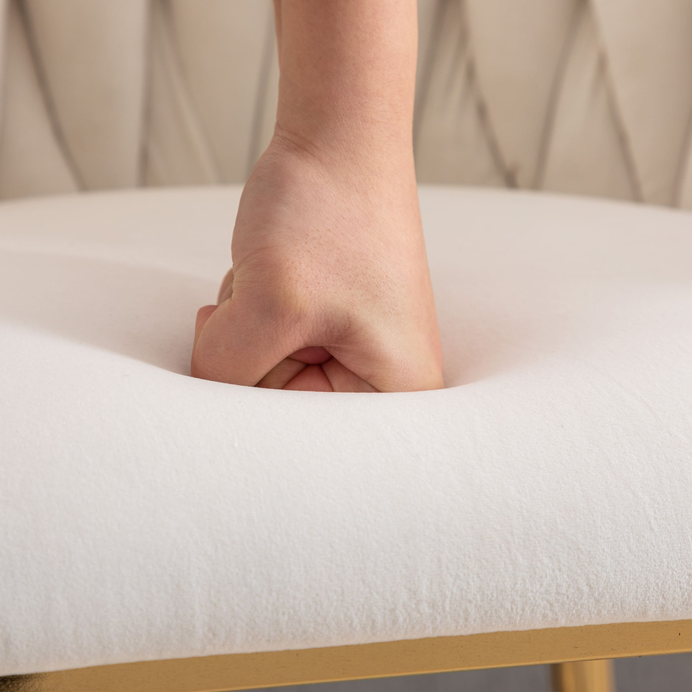Hand pressing into upholstered cushion of stool