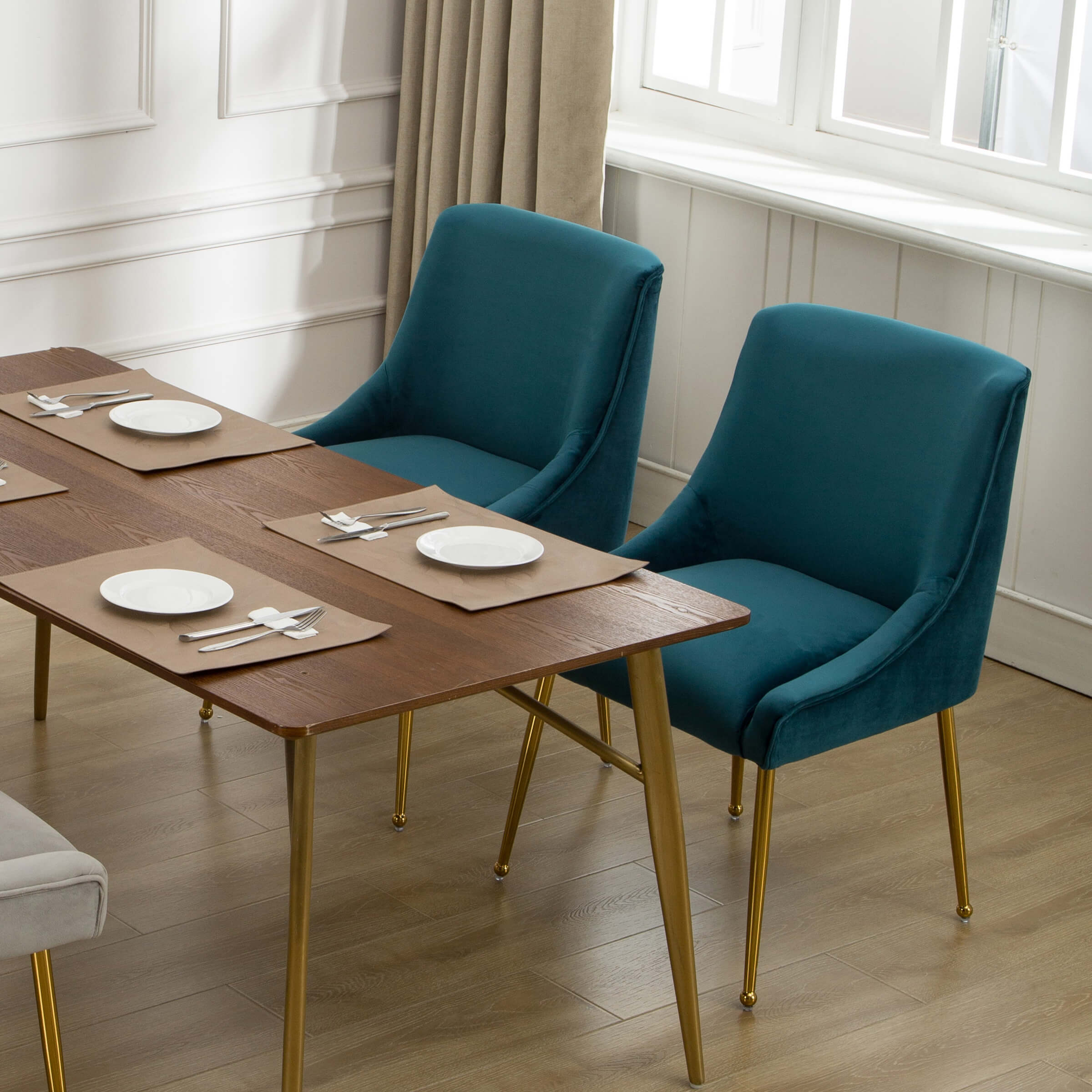 Teal velvet dining chair at a dining table with place settings with two chairs