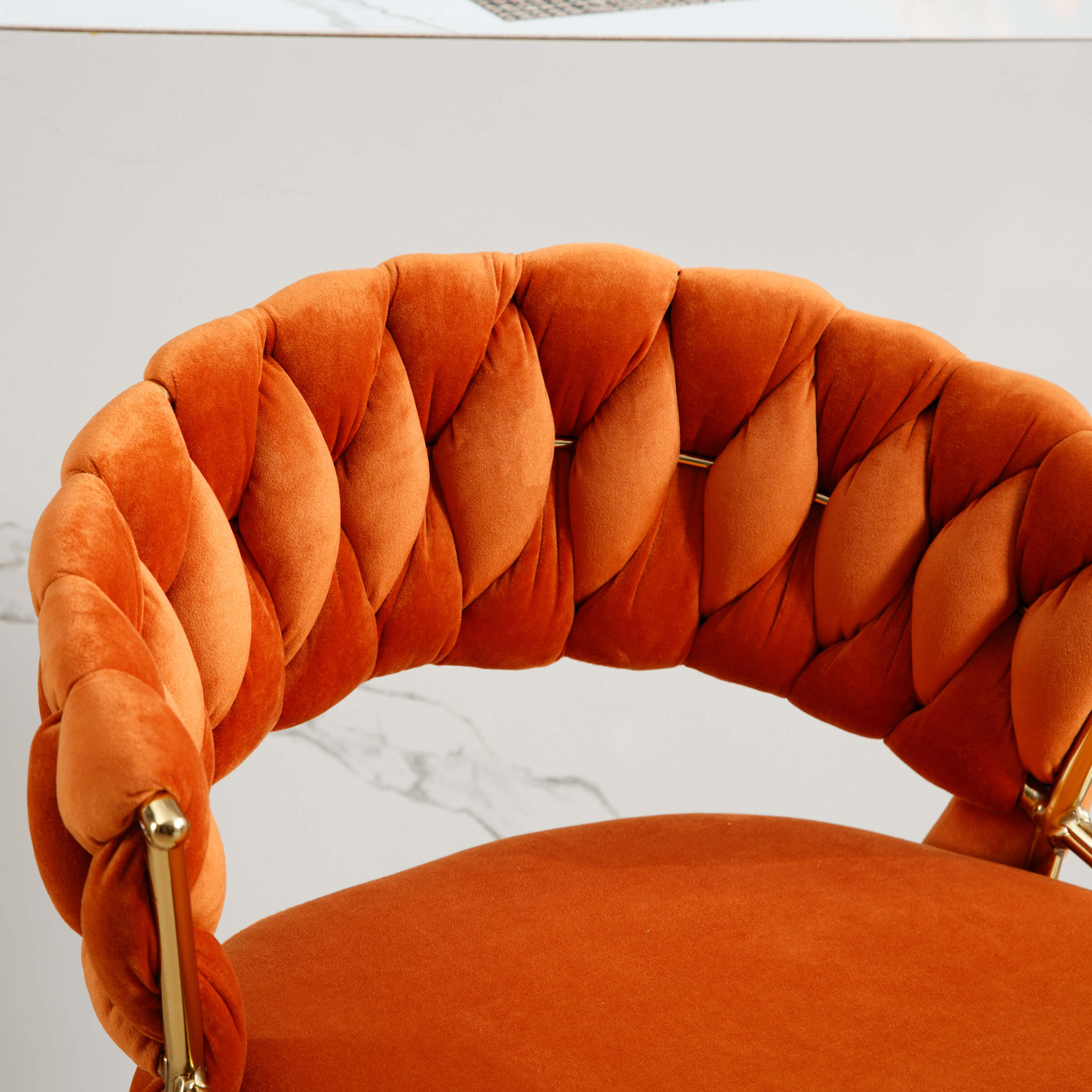Close-up of orange velvet braided back on stool