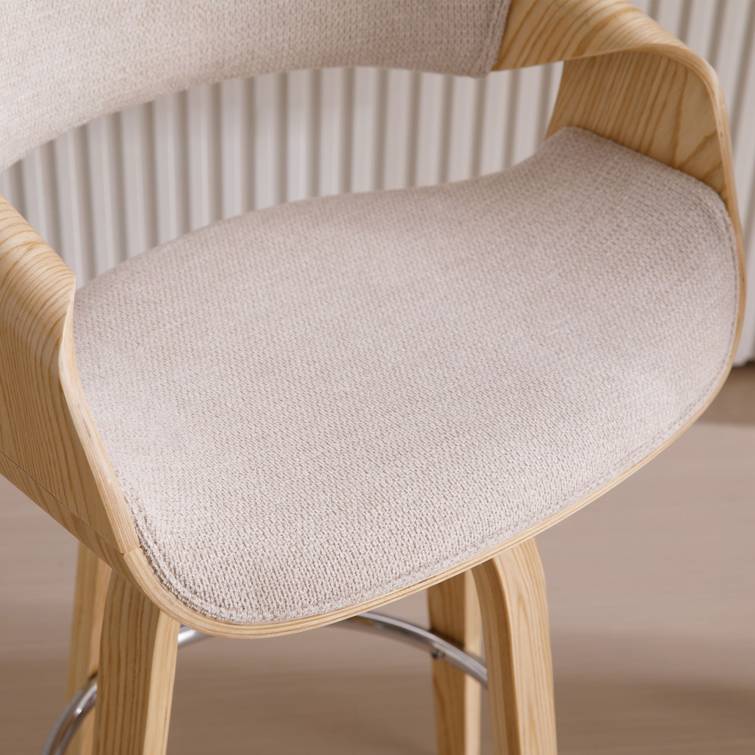 Close-up of beige upholstered seat and wooden arm