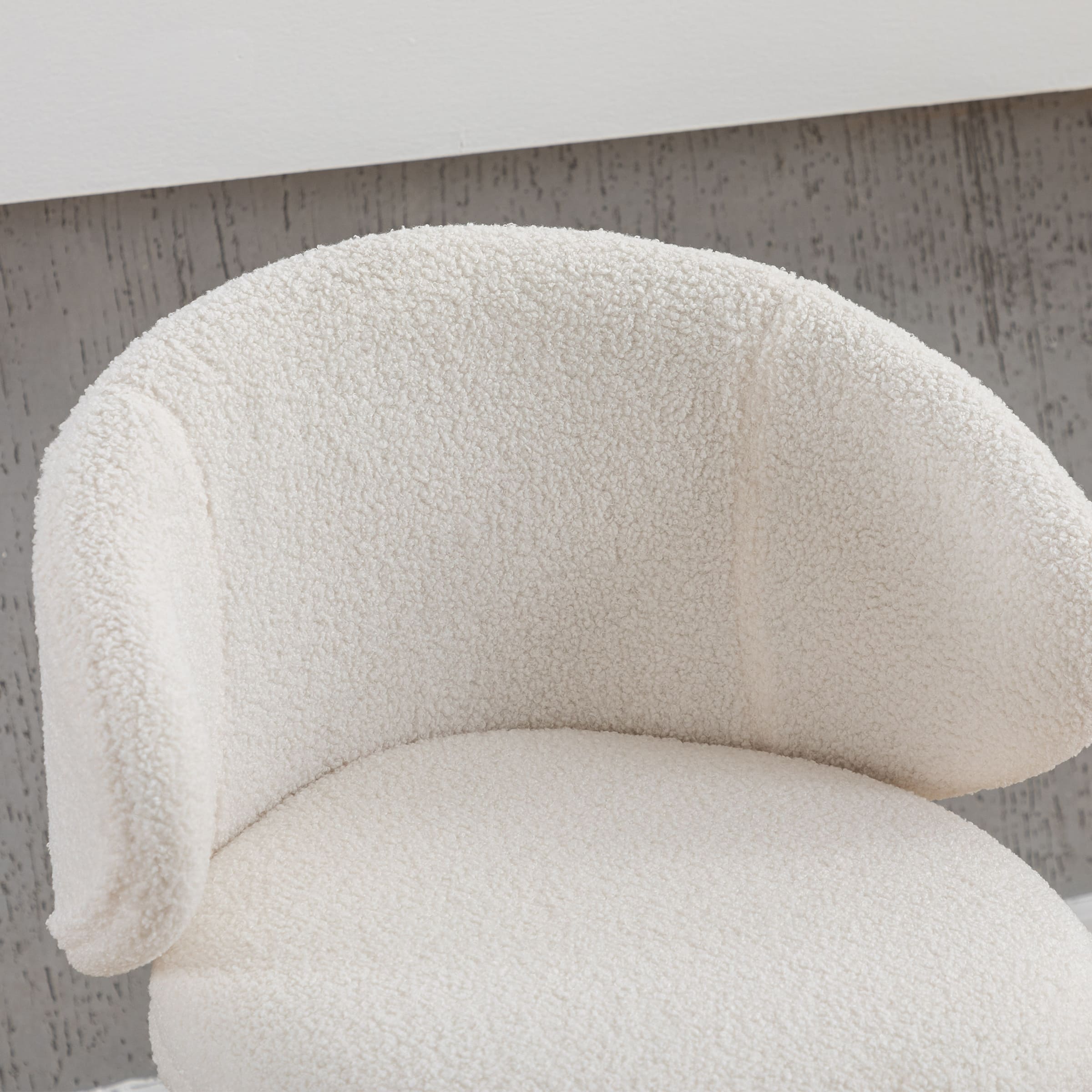 Close-up of the textured cream boucle upholstery on chair back