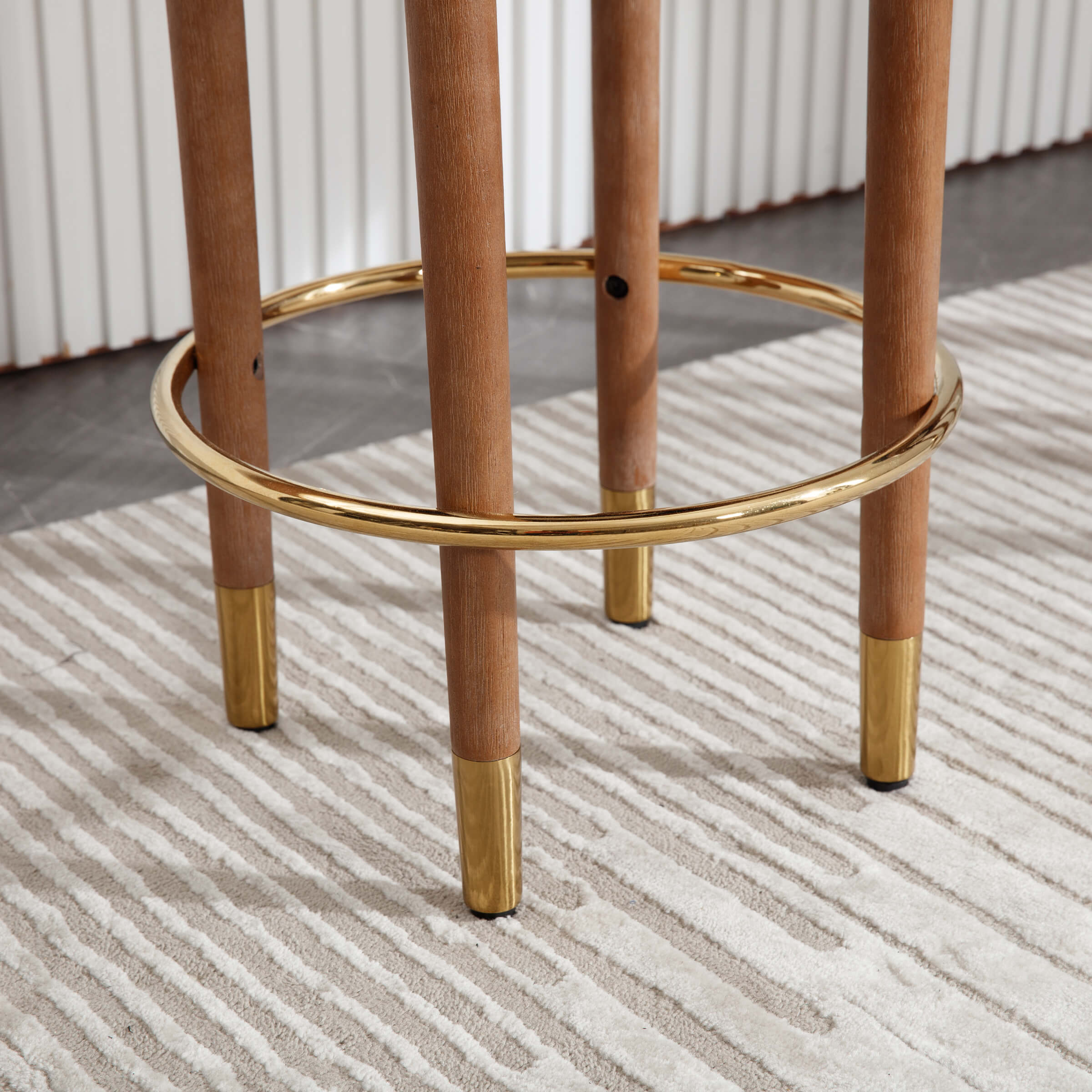 Two stools with gold rings and wooden legs on a rug