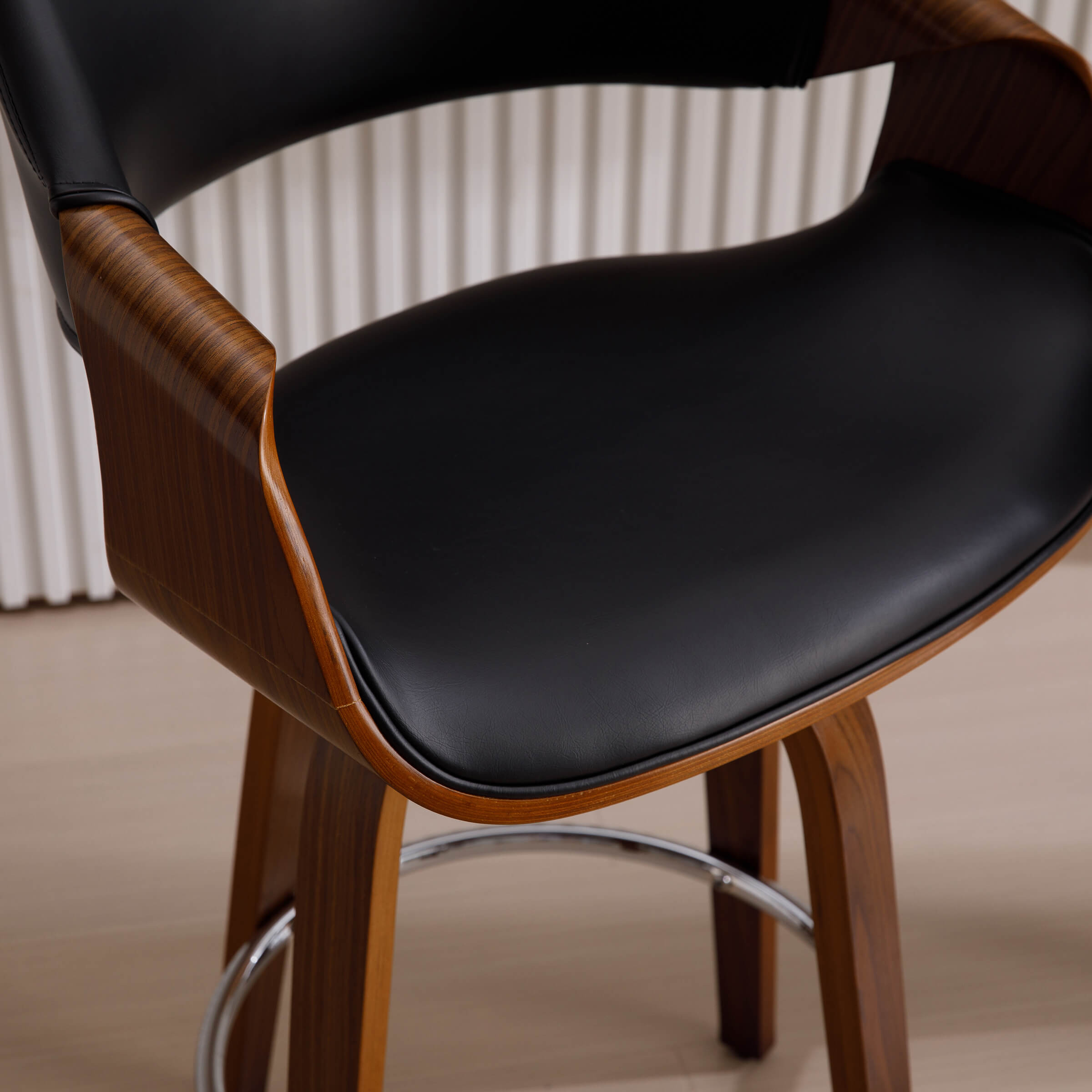 Close-up of black seat and wooden arm