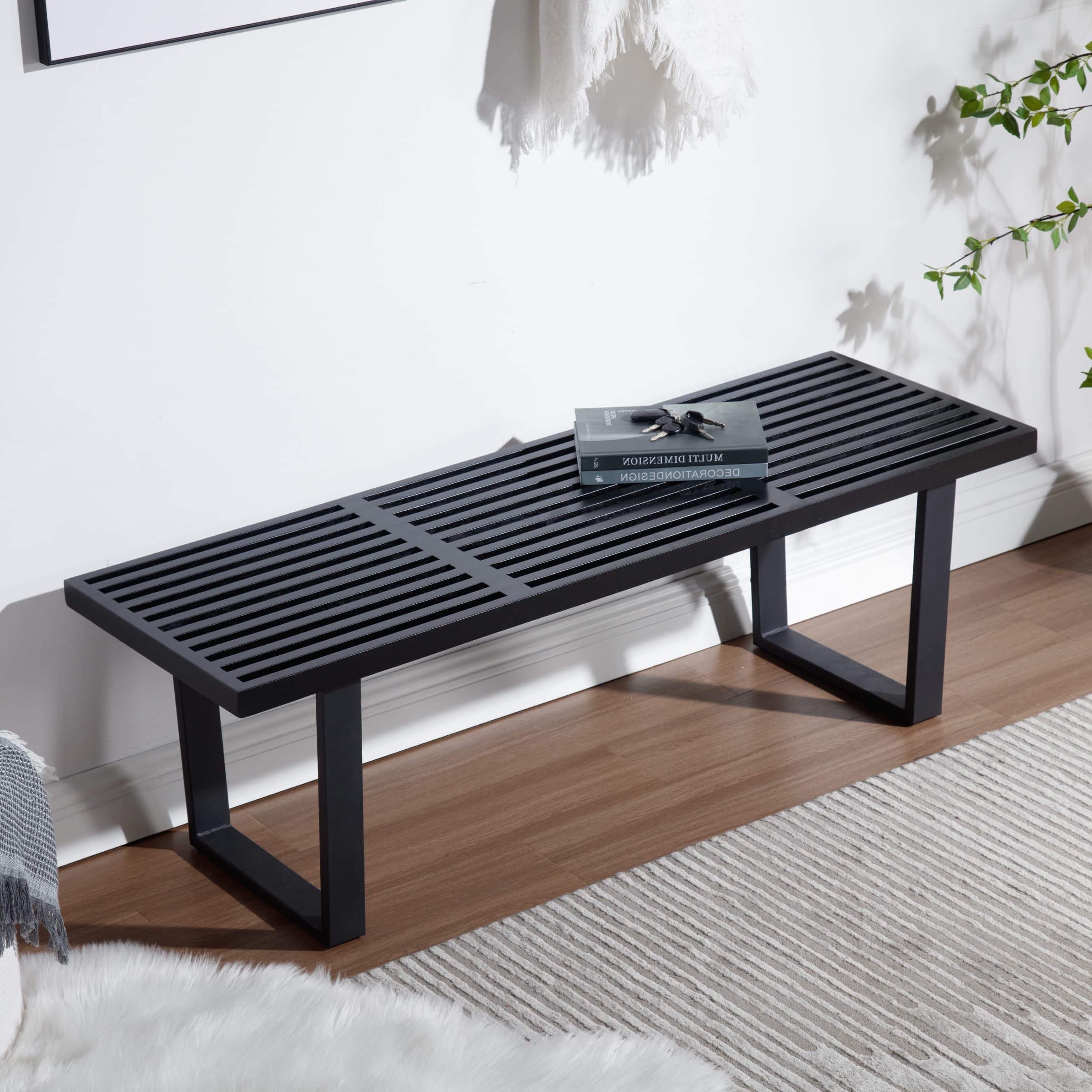 Black slatted bench in room setting