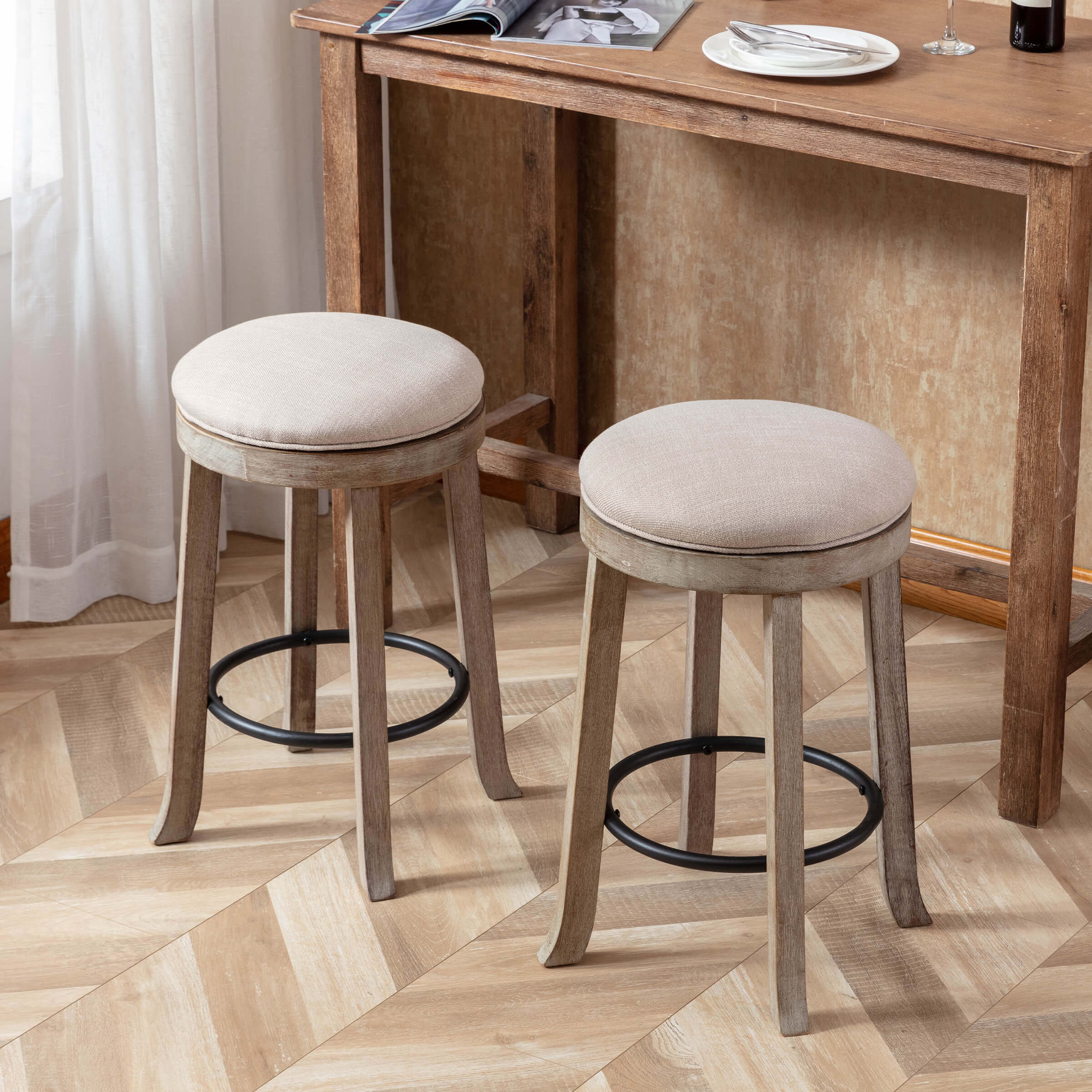 Two beige round backless stools at a wooden dining table