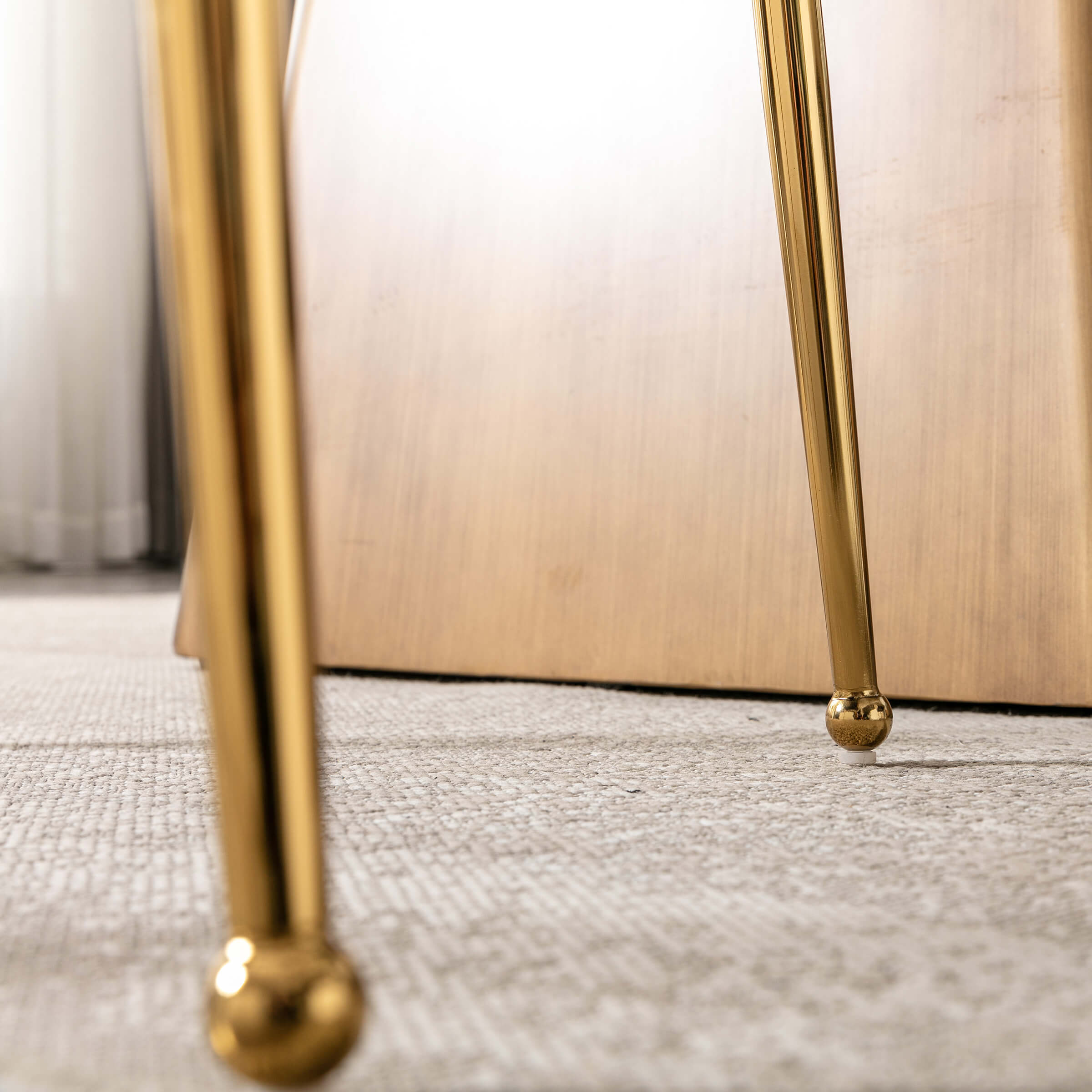Close-up of gold chair leg tip on carpet