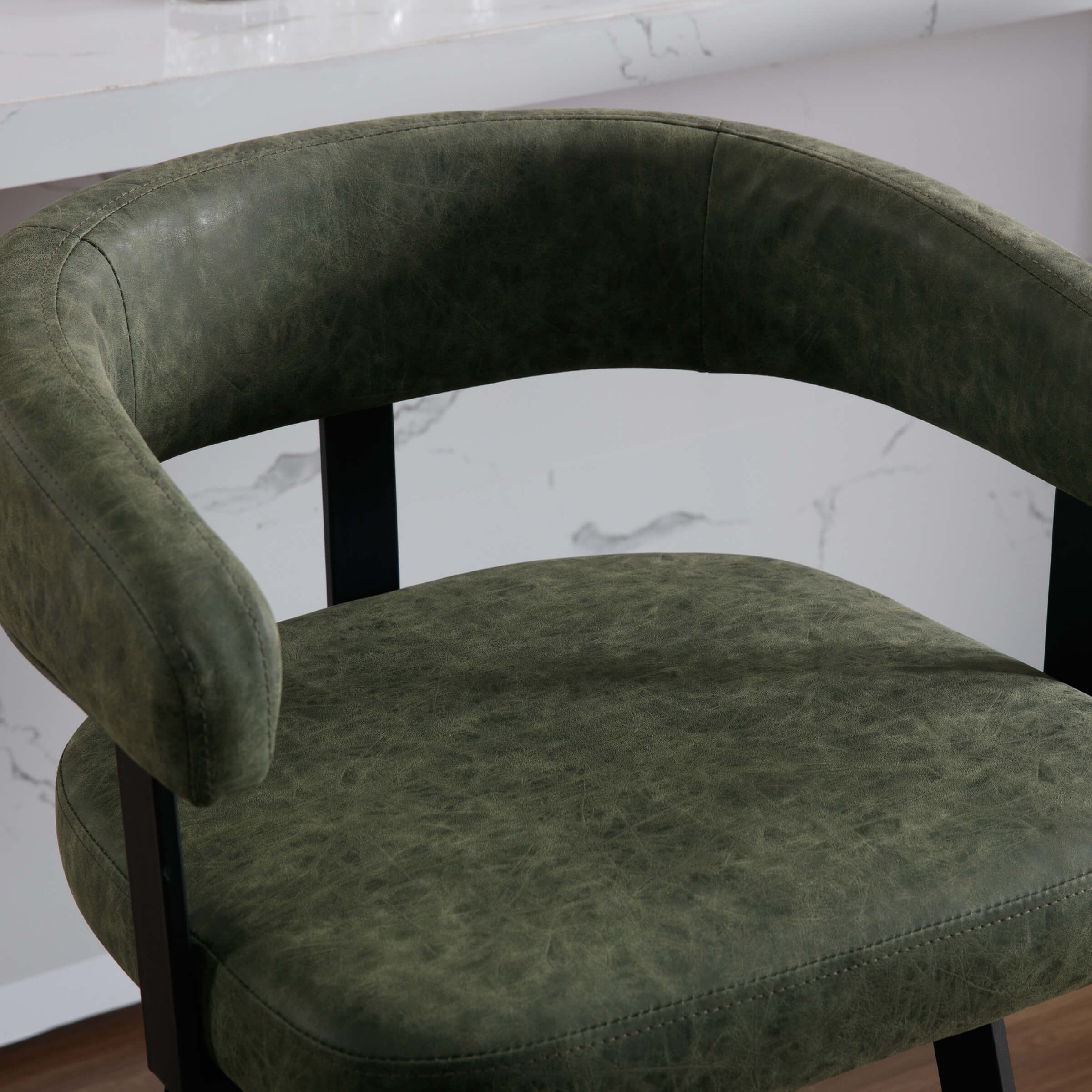 Close-up of green leather seat and armrest of bar stool