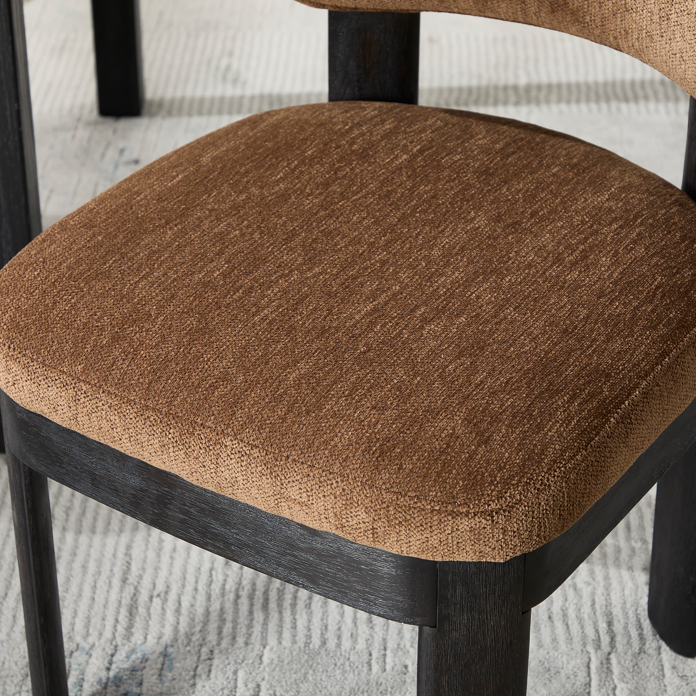 Brown upholstered seat and black legs
