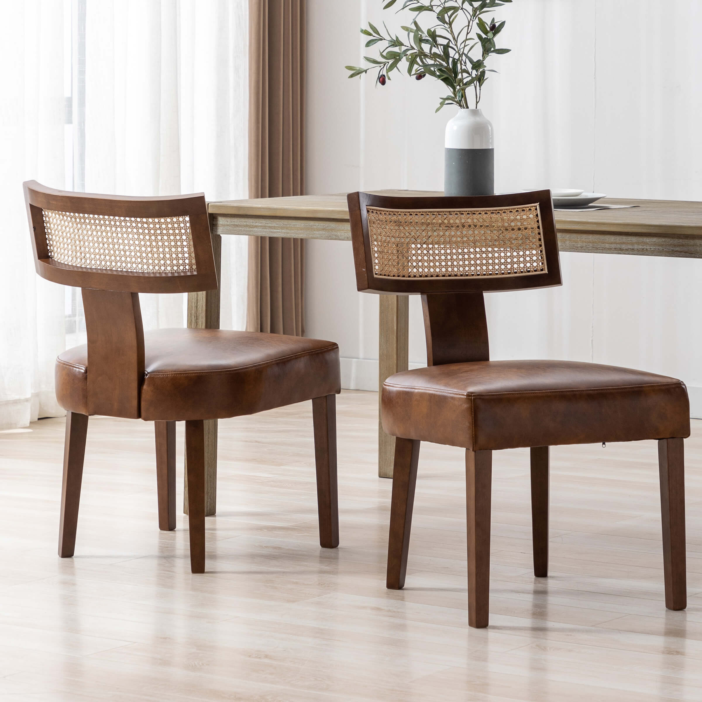 Two chairs around a table with plant centerpiece