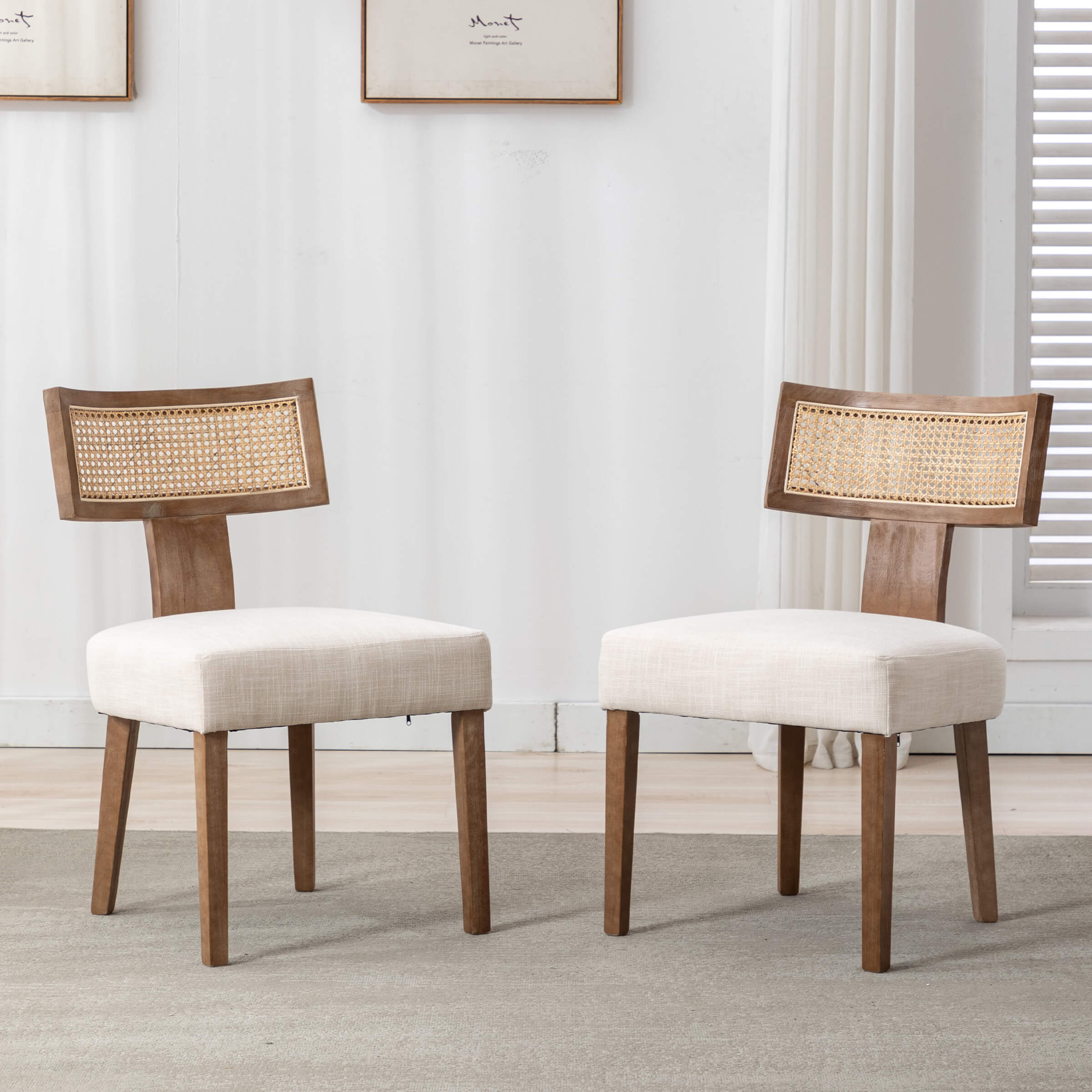 Two farmhouse dining chairs with linen beige seats and rattan backrests in a living room