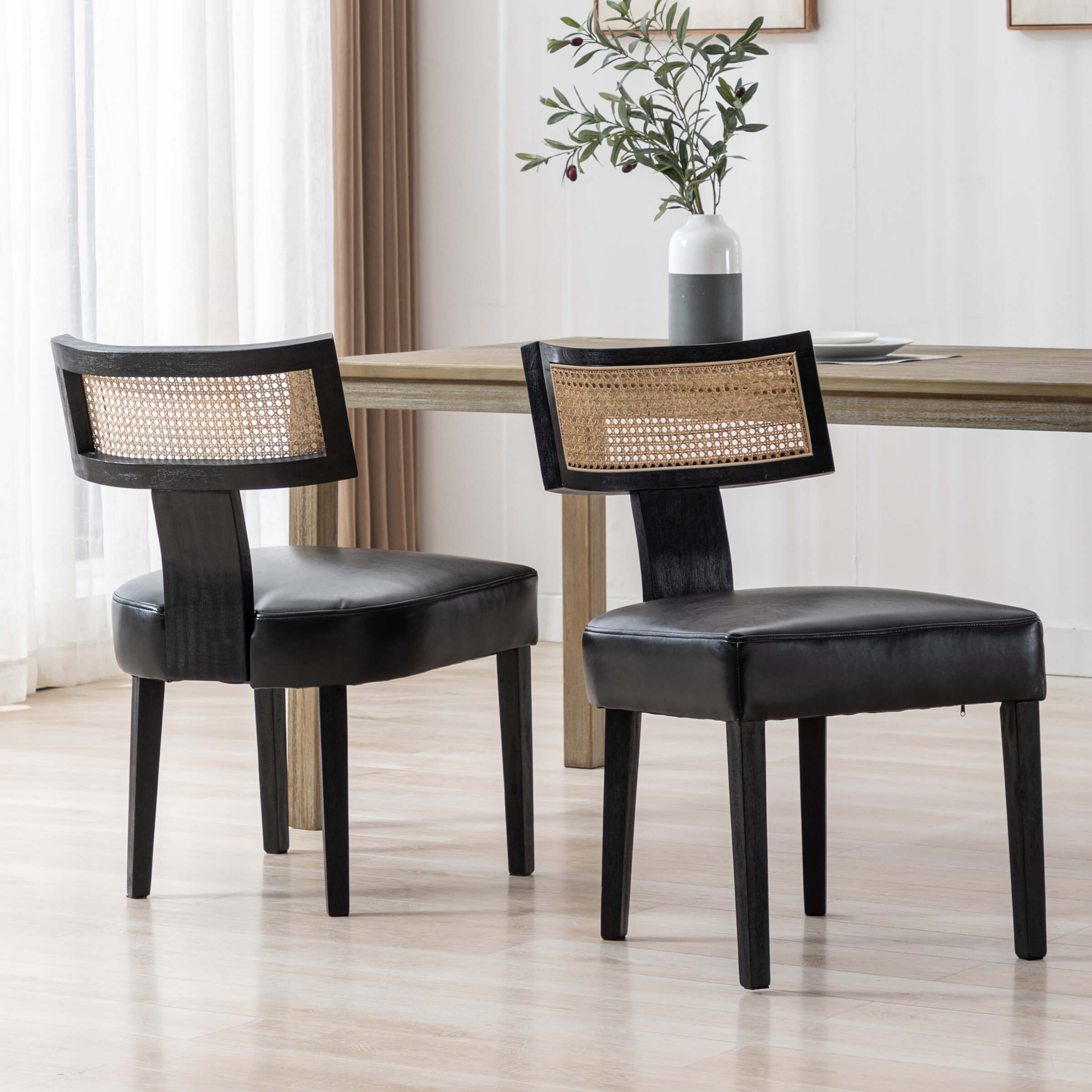 Two chairs with cane backs and black legs