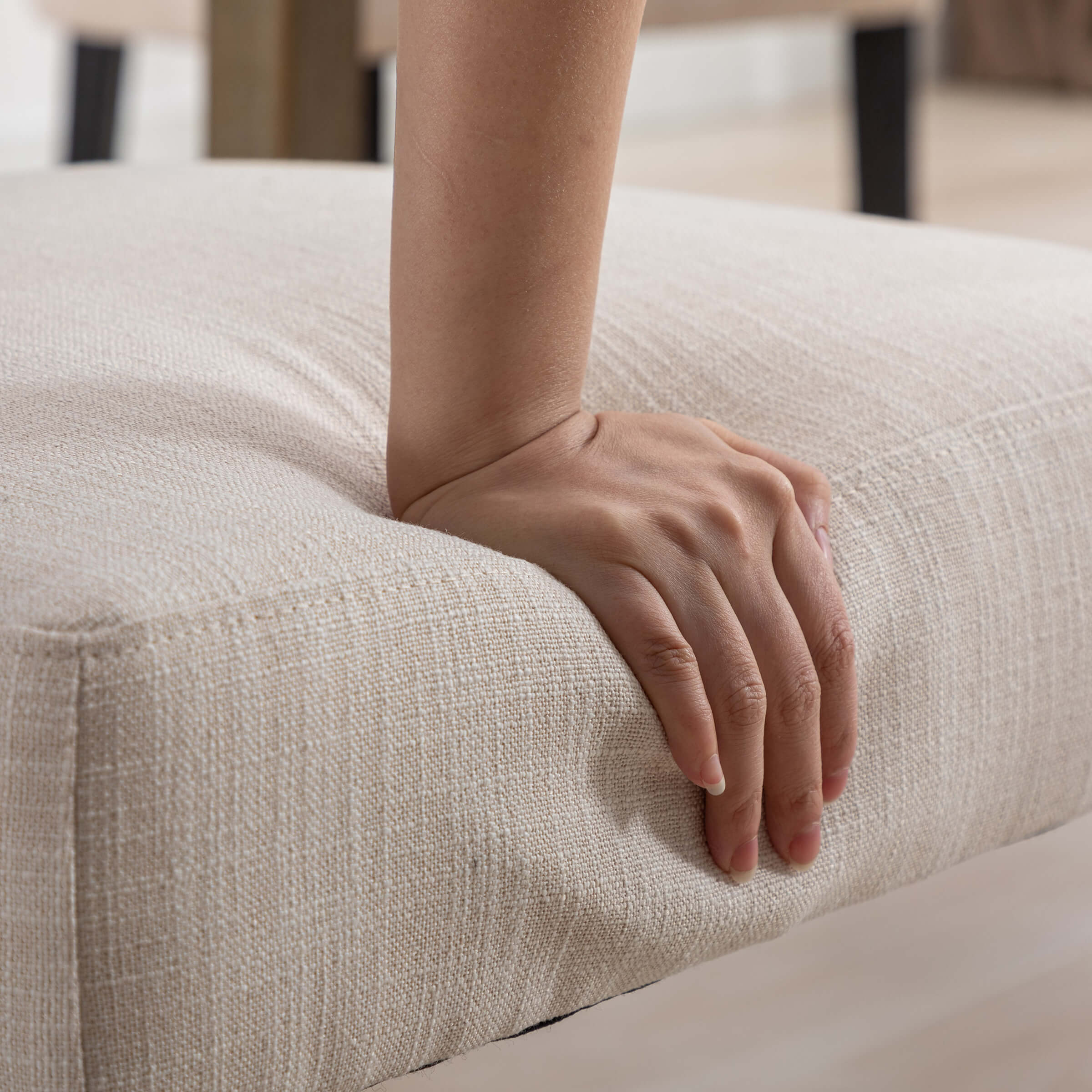 Hand pressing the edge of seat cushion