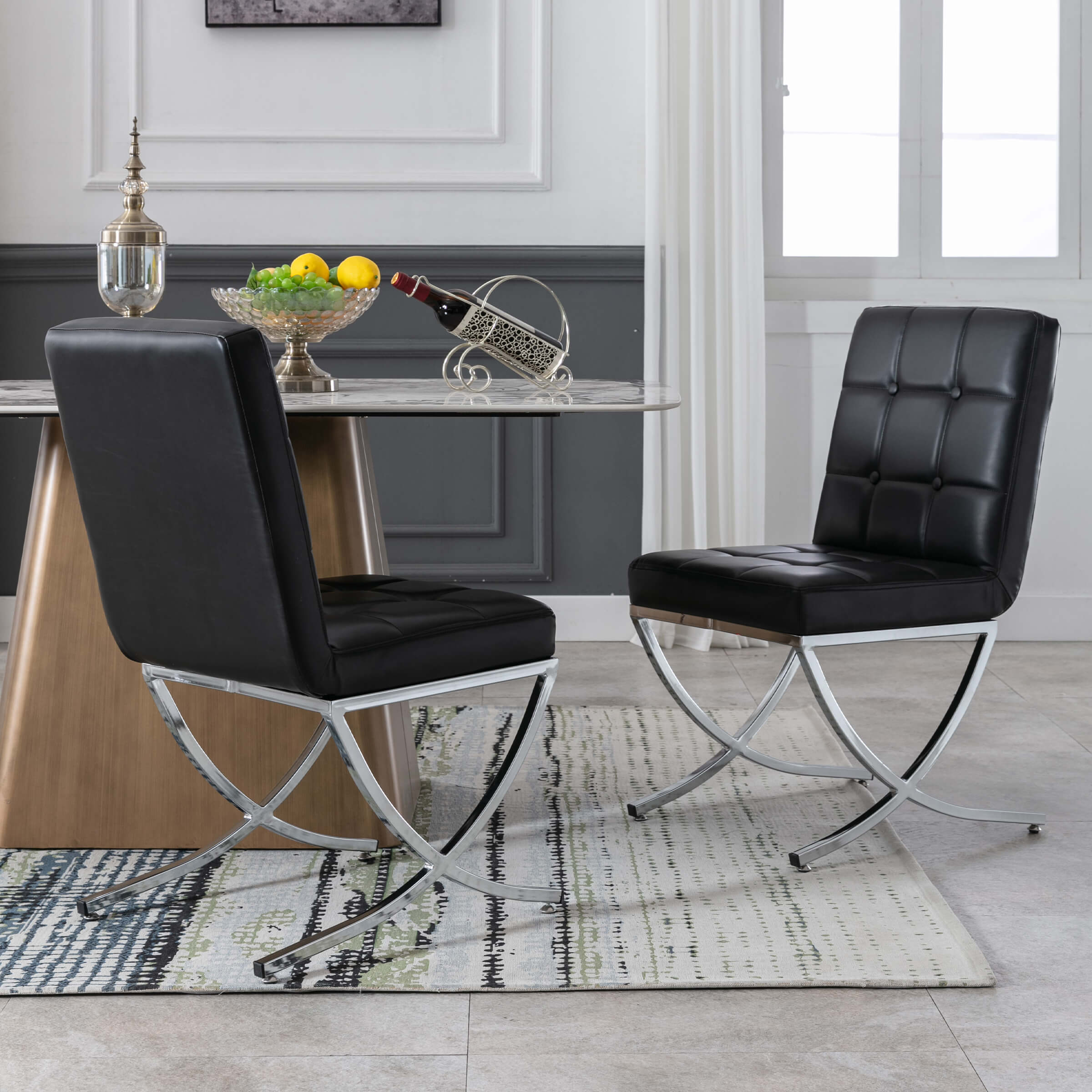 Two black tufted chairs beside round table