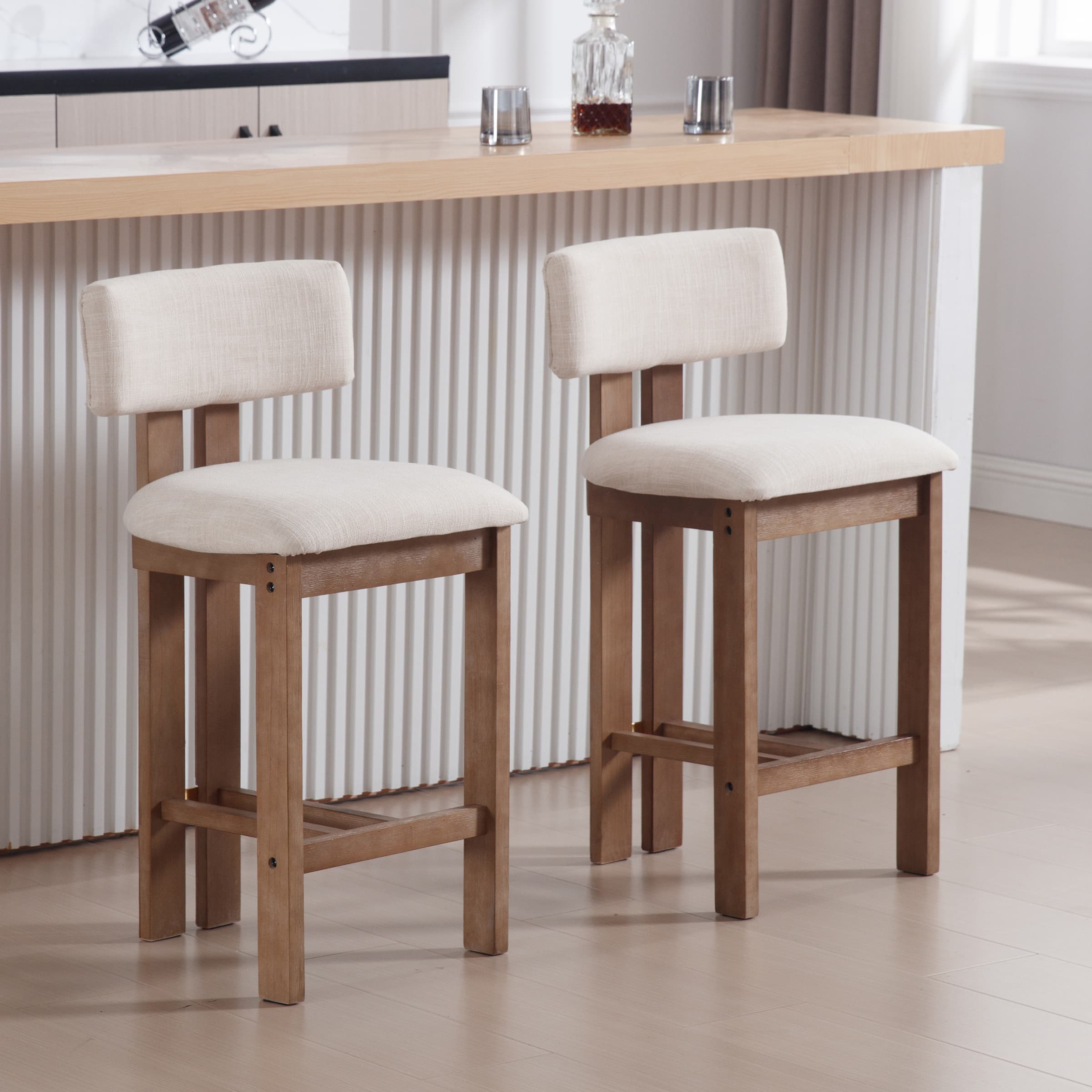 Two beige upholstered counter stools at a kitchen island