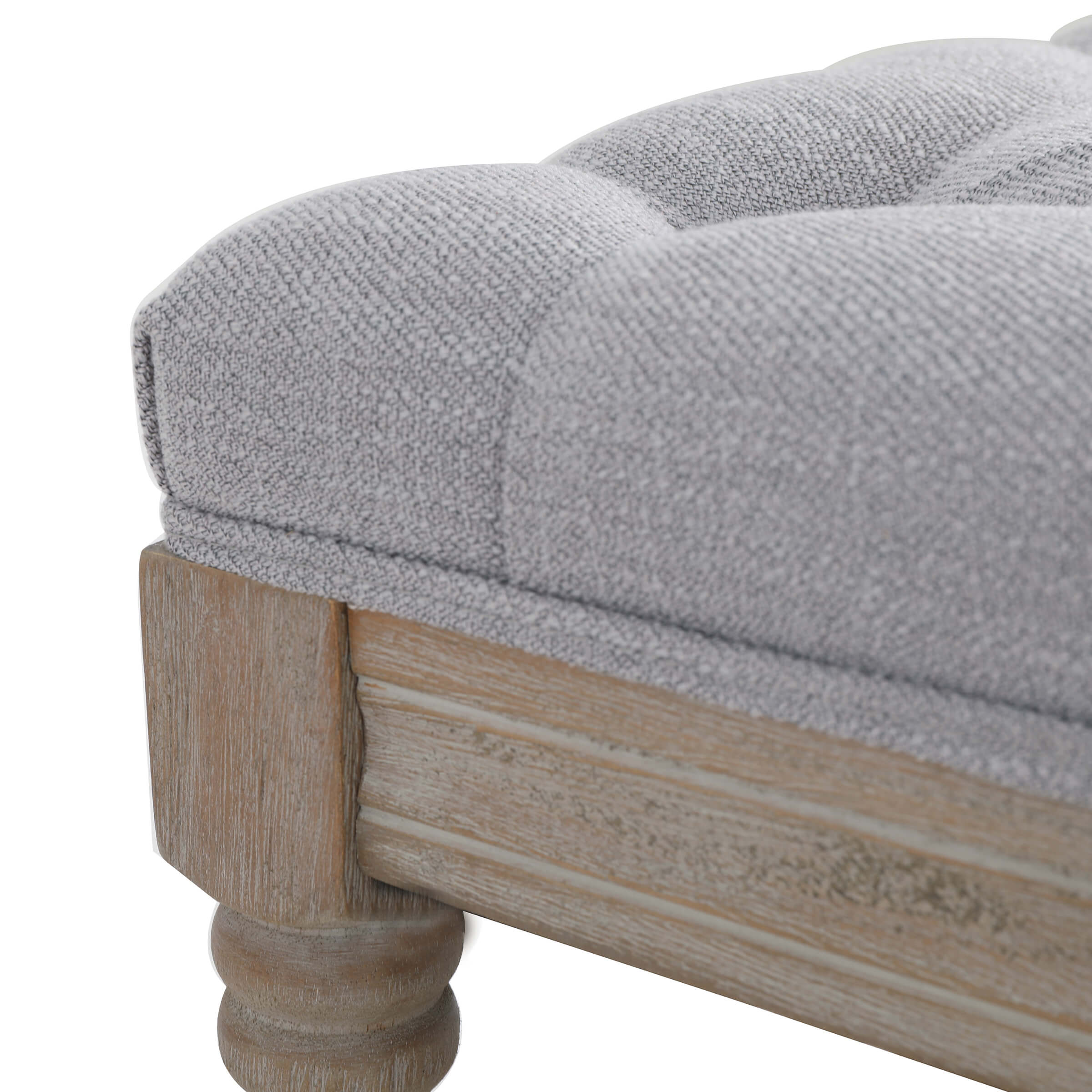 Close-up of tufted cushion and wooden leg