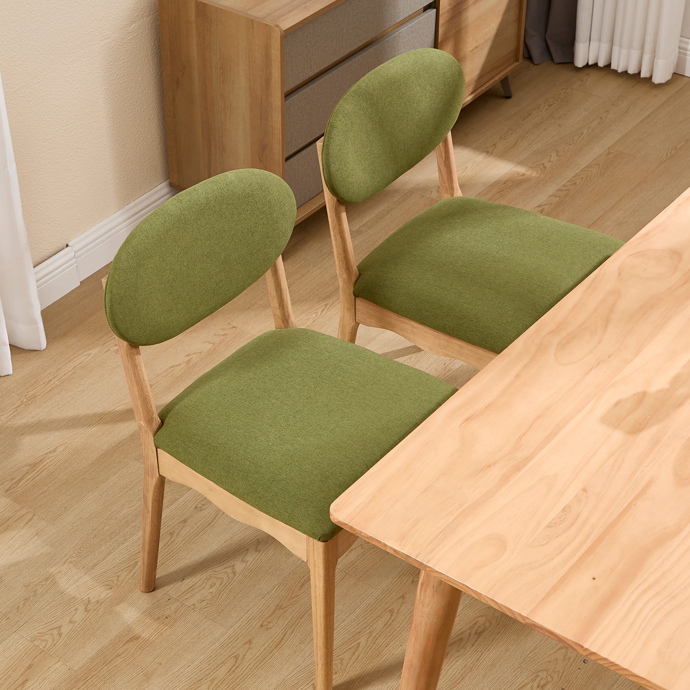 Close view of green upholstered chair seat and wooden legs
