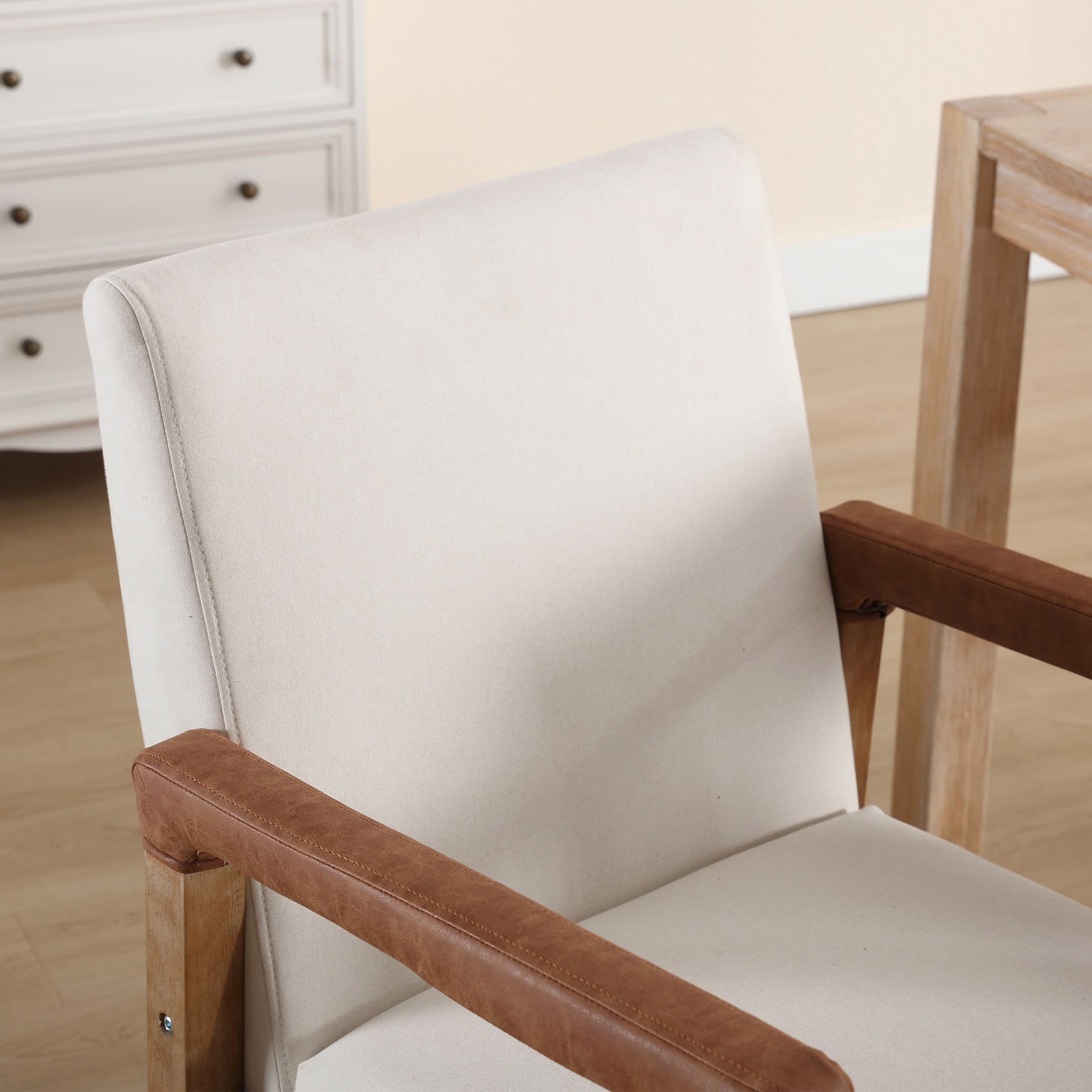 Close-up of chair back and armrest with cream upholstery