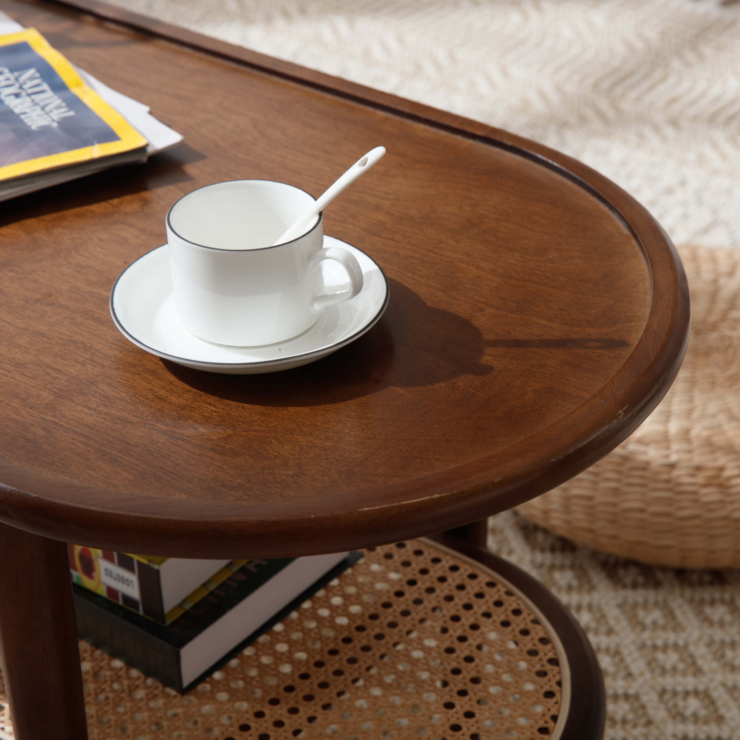 White teacup and saucer with spoon on round wooden table surface