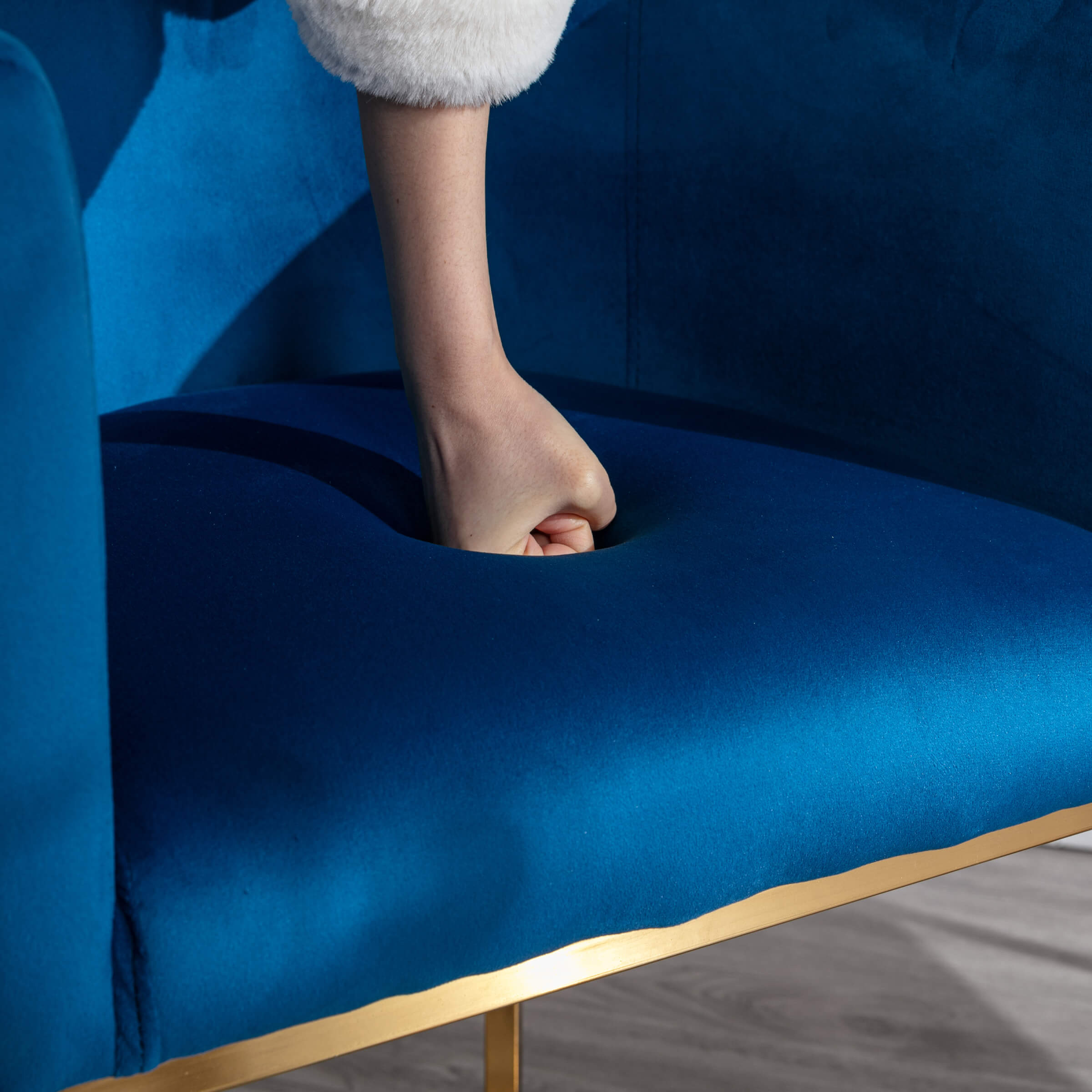 Finger press into blue seat cushion