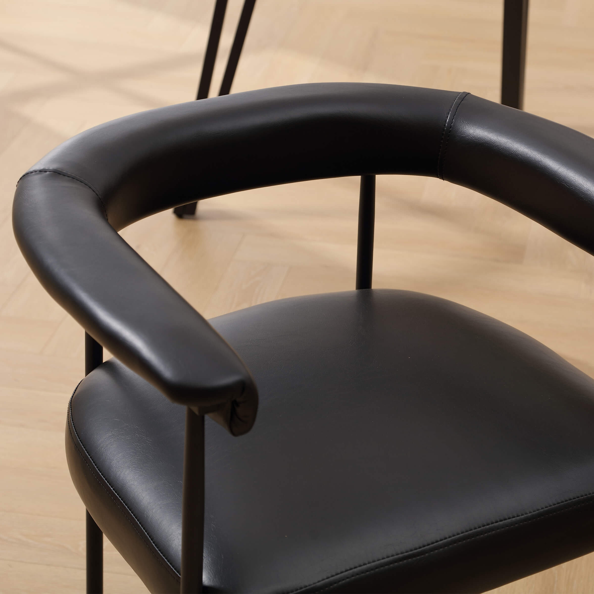 Black leather-like seat with armrest close-up