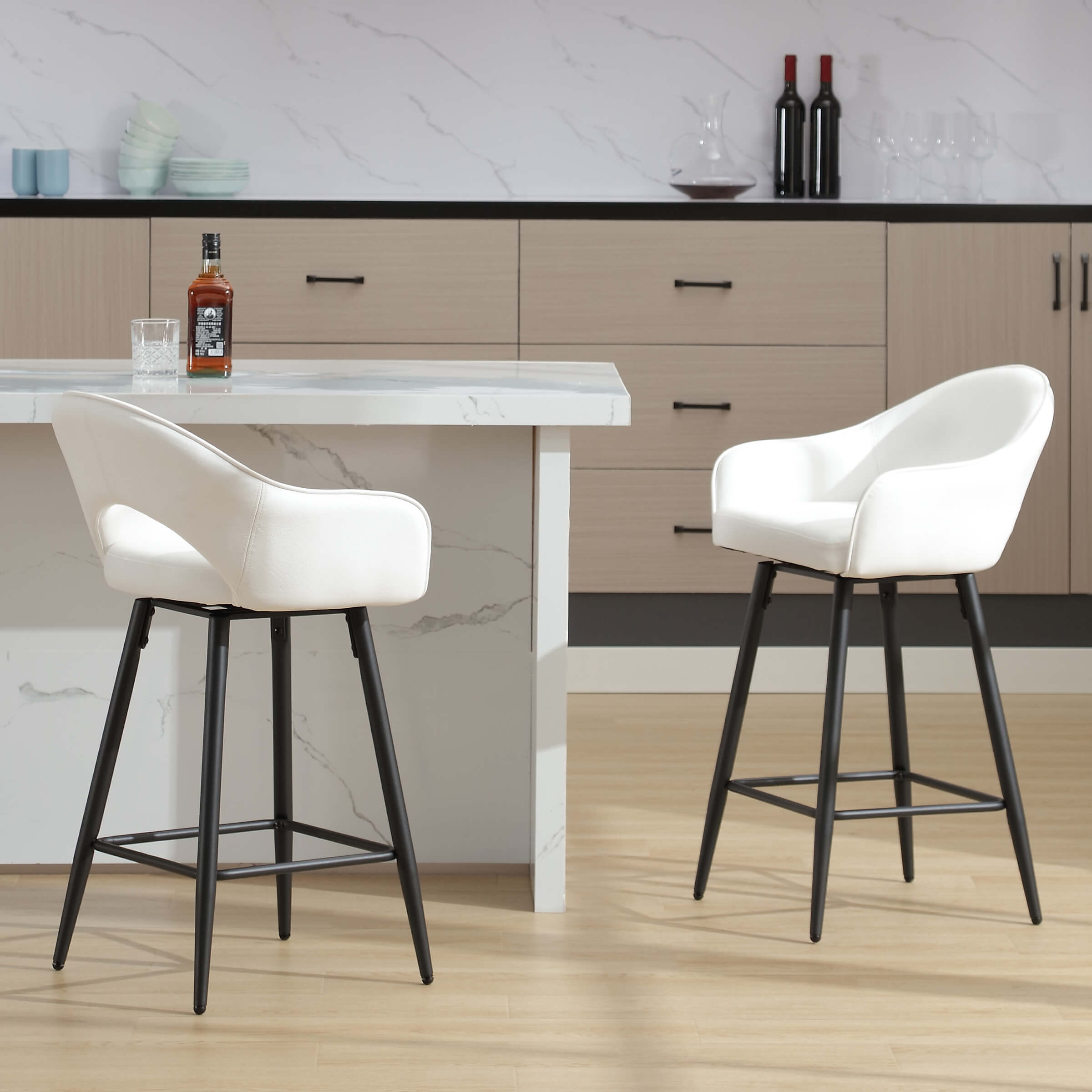 Front-right view of two white swivel counter stools at island