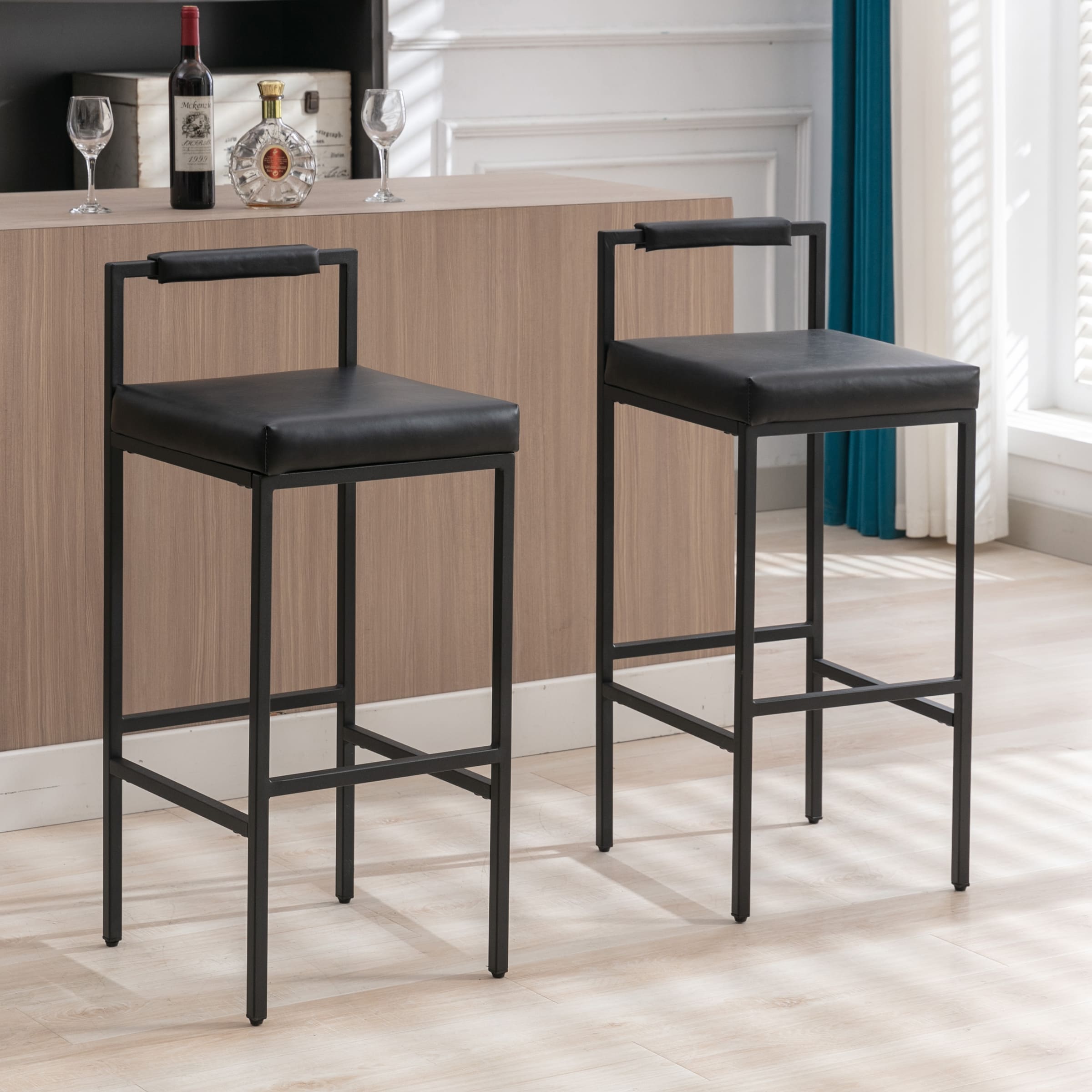 Two stools with black seating at a bar
