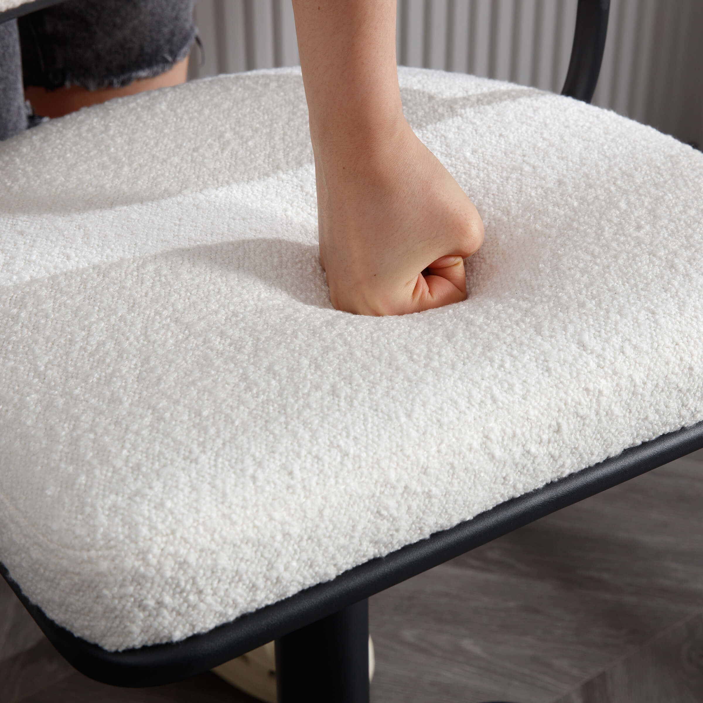 Person pressing into sherpa stool seat