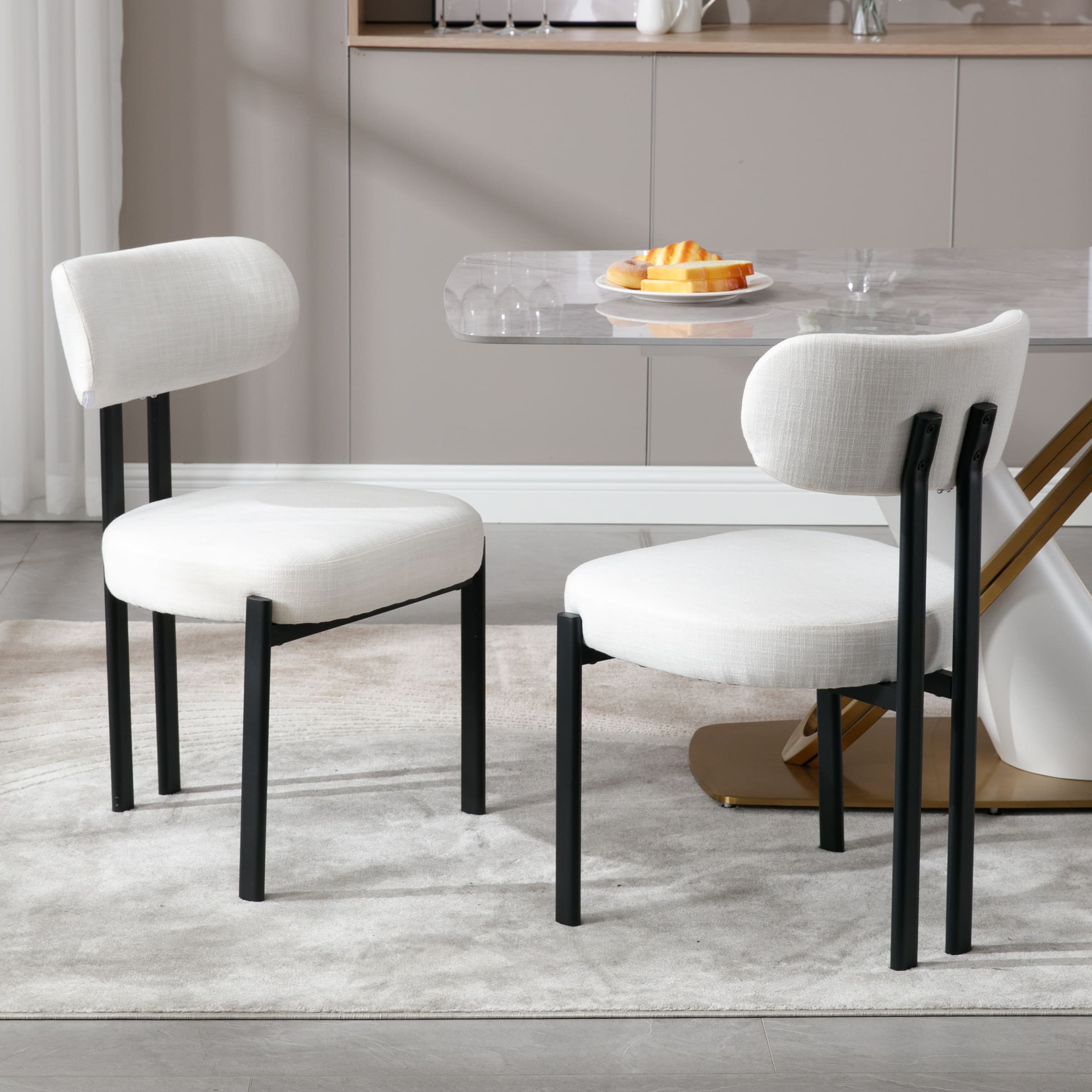 Dining chairs around a glass dining table in a modern kitchen setting