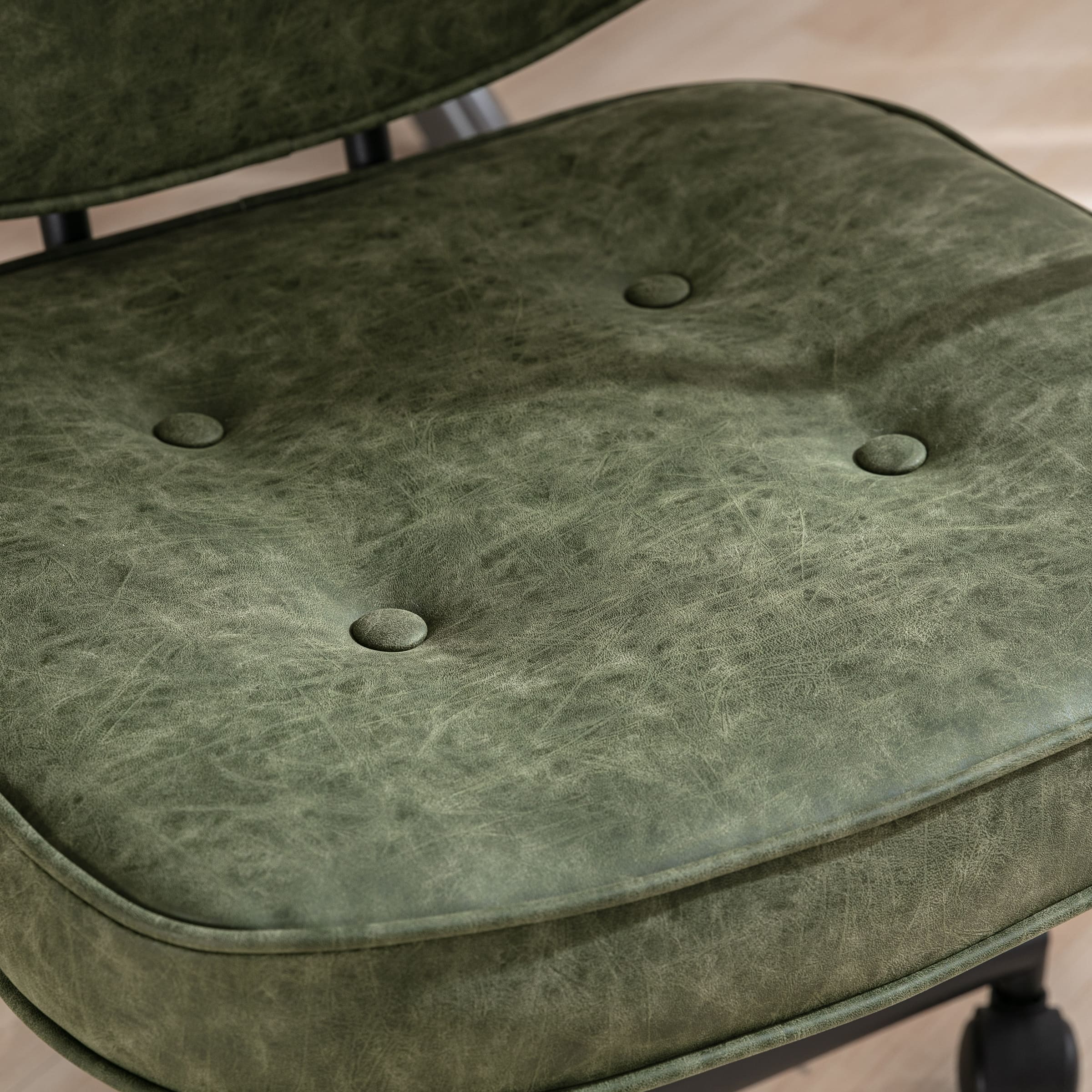 Close-up of green button-tufted seat cushion