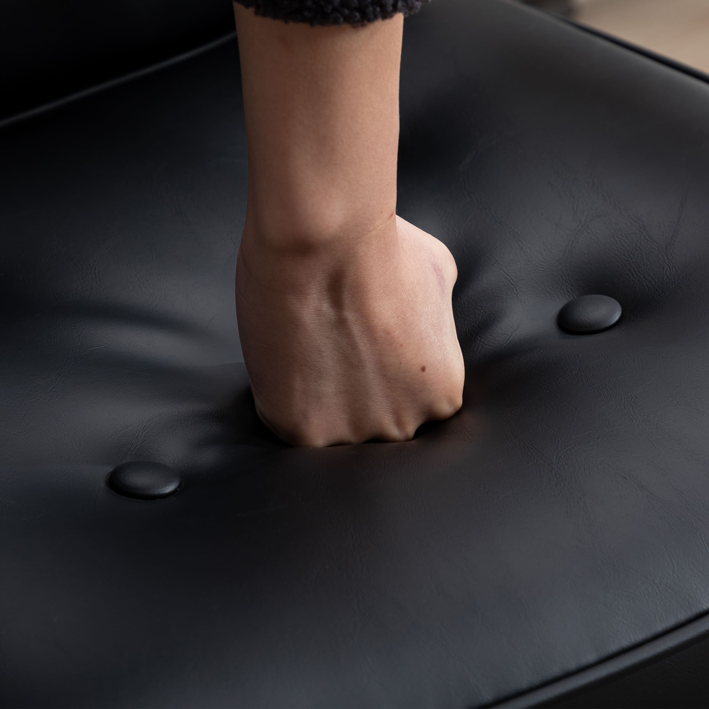 Hand pressing black cushion