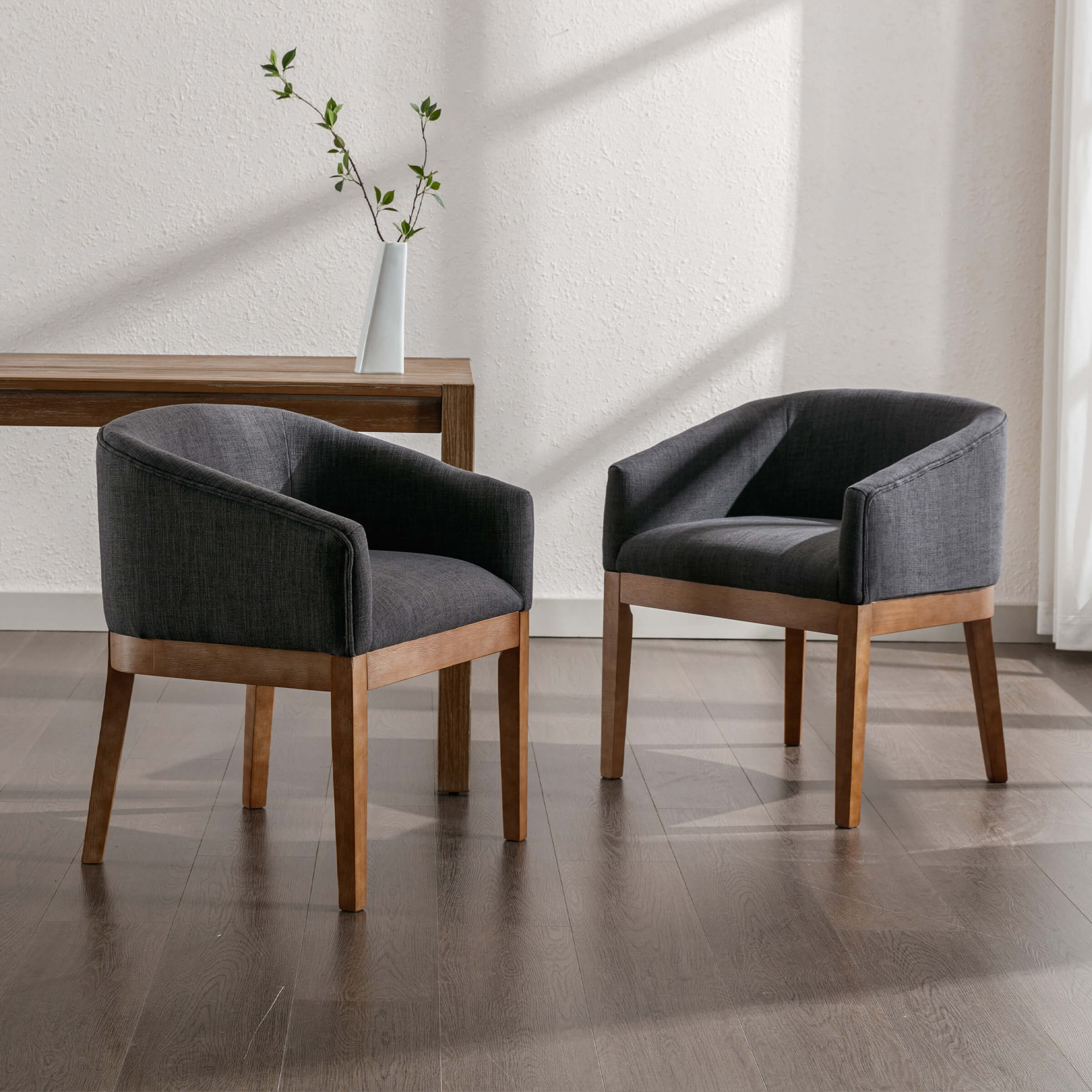 Two chairs with dark upholstery and black legs