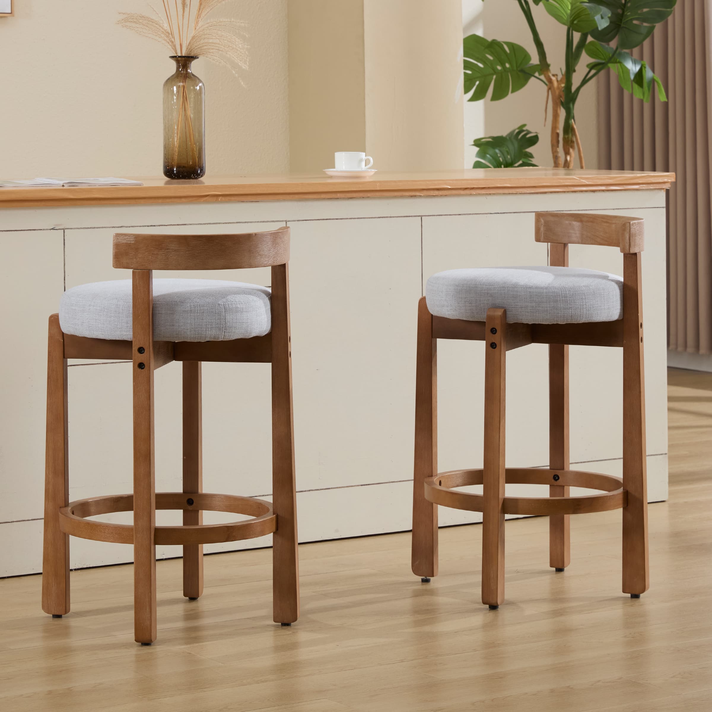 Two stools with gray cushions at counter