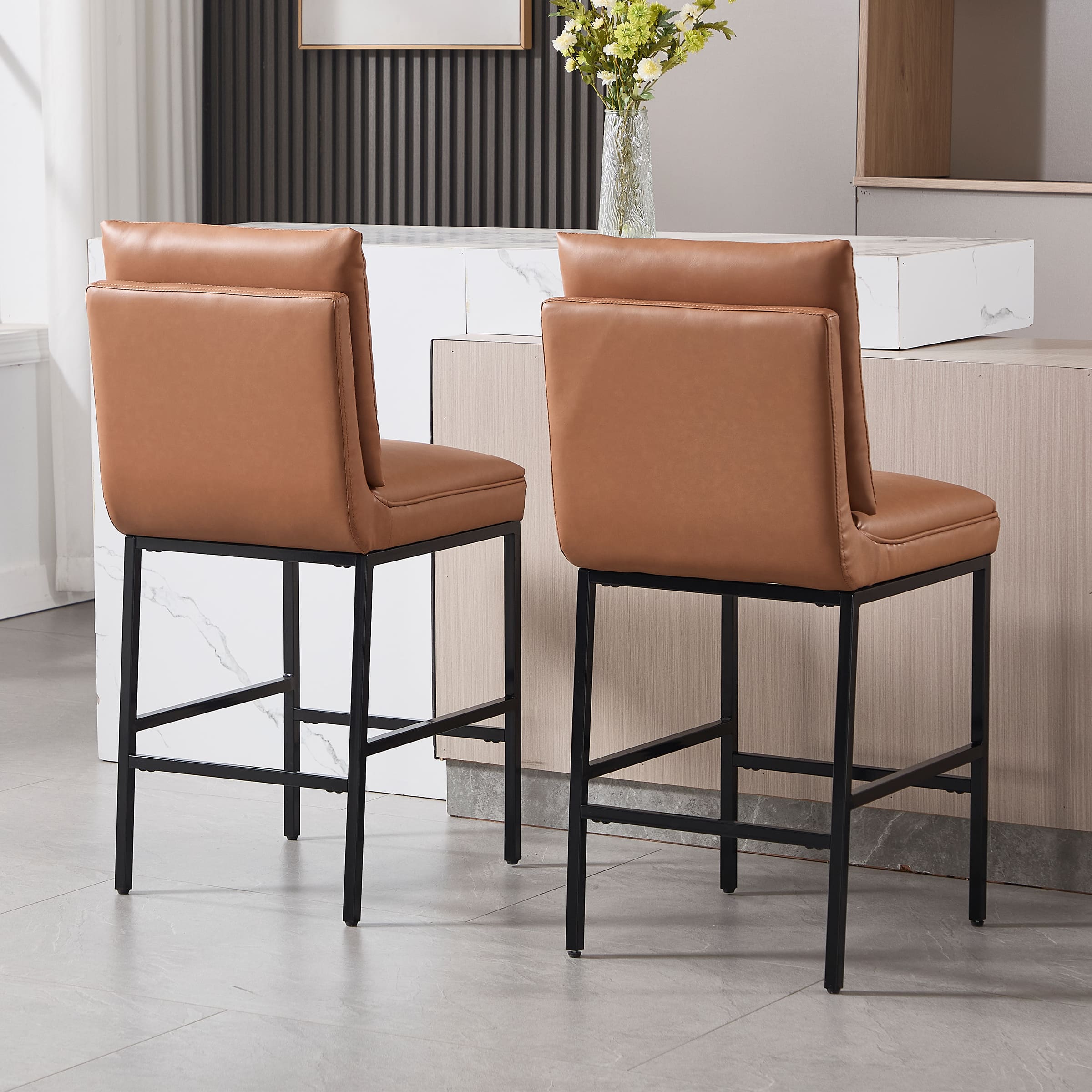 Two brown leather stools seen from back and side
