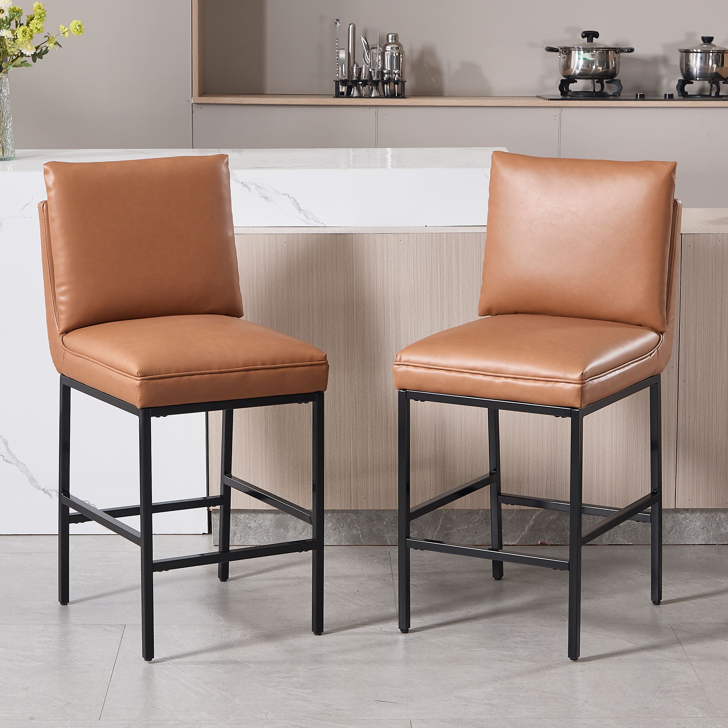 Two brown leather stools at kitchen counter